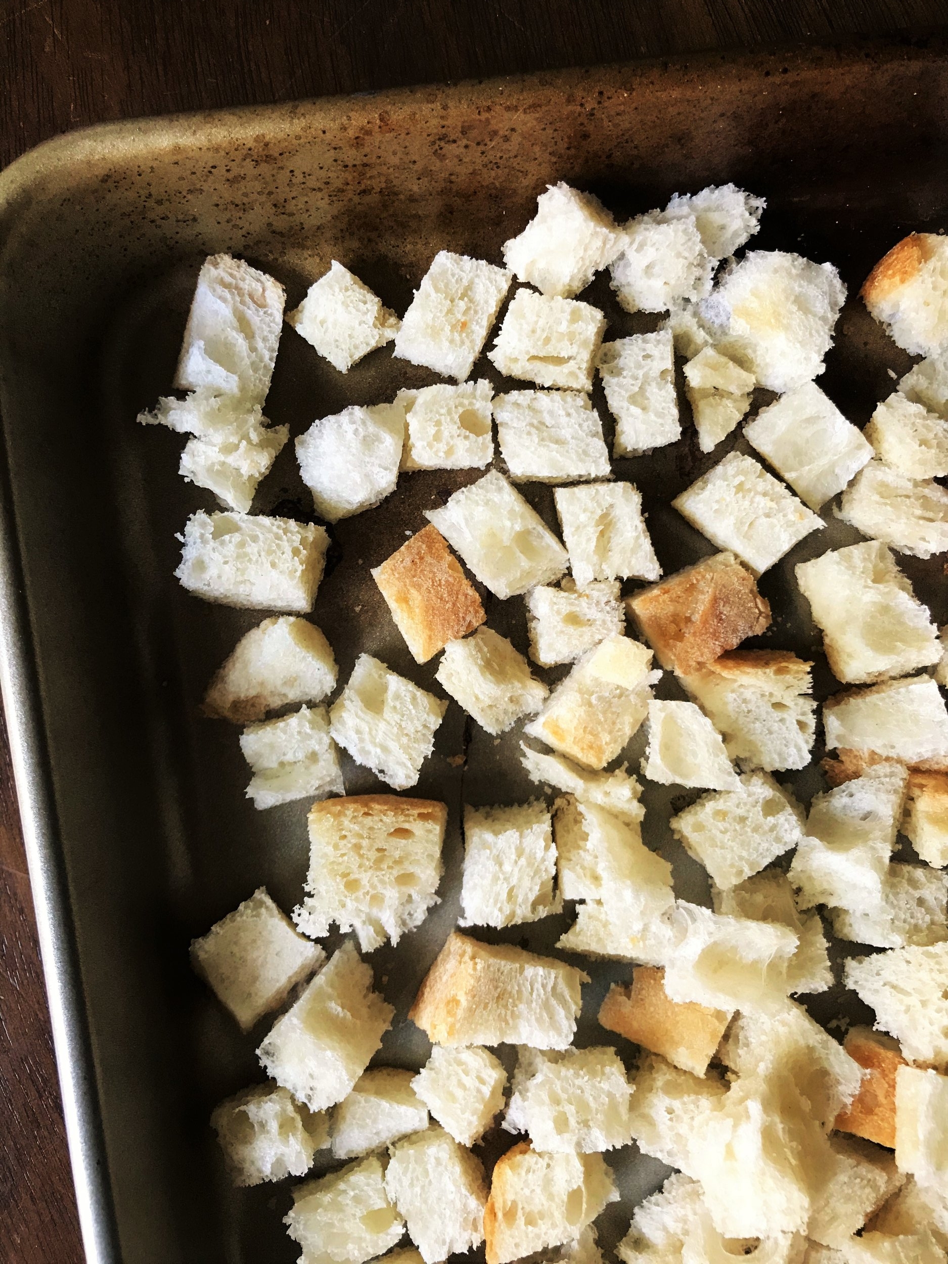 Cubed bread for stuffing, spread out on a baking sheet to dry out.