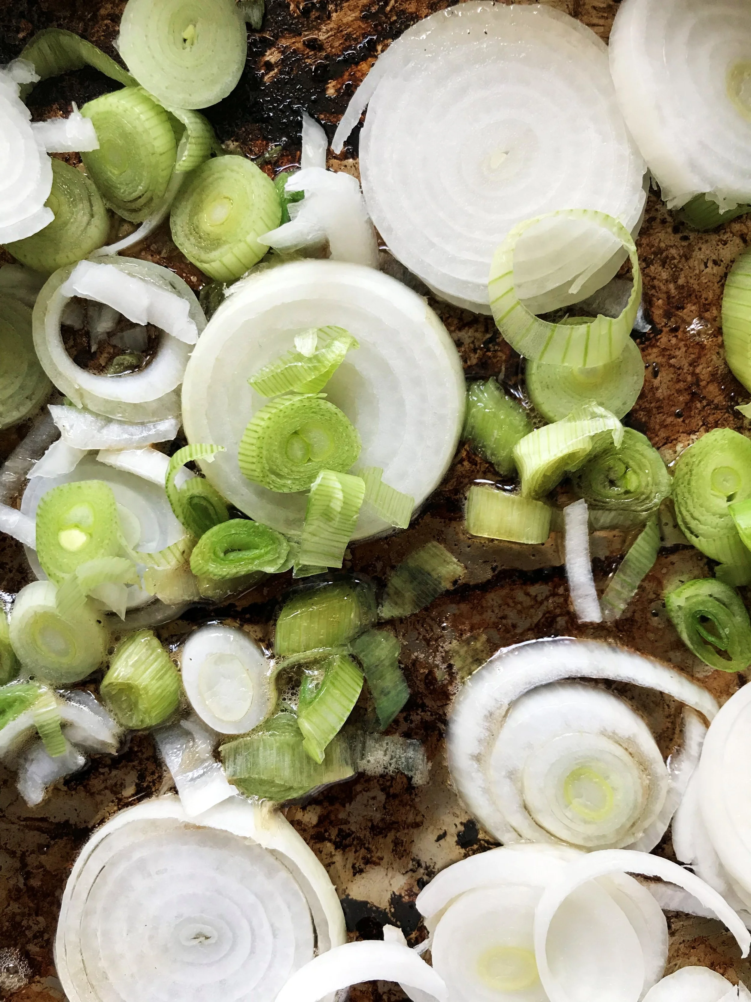 Sauteeing my sliced spring onions in bacon fat and olive oil. Once they’ve softened up, the garlic, ginger and preserved lemons go into the pan, and then it gets finished it off with a splash of champagne vinegar.