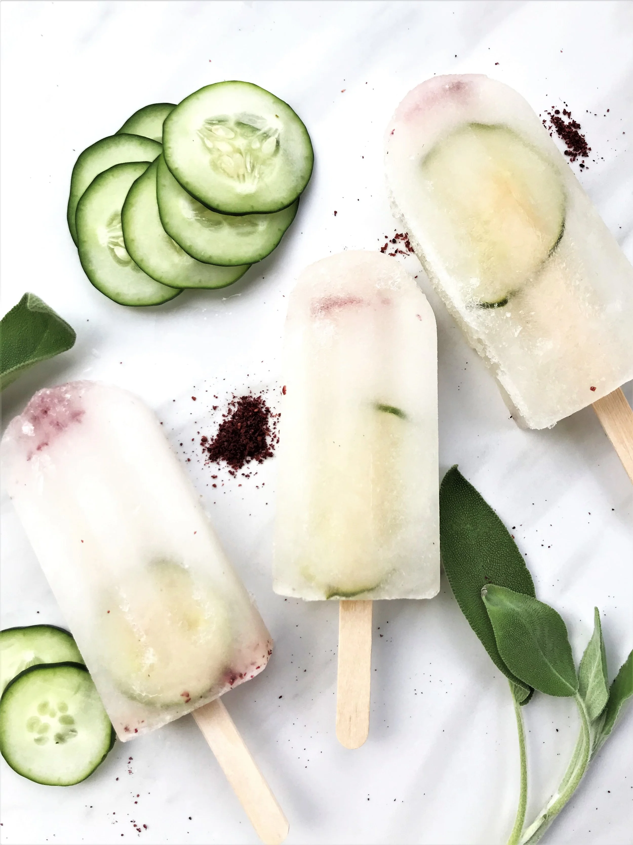 Sweet Cucumber Spice Pops with Sumac and Sage, made in the Adventure Kitchen. Each pop will have a thin slice of cucumber visible through the pop. Yum!