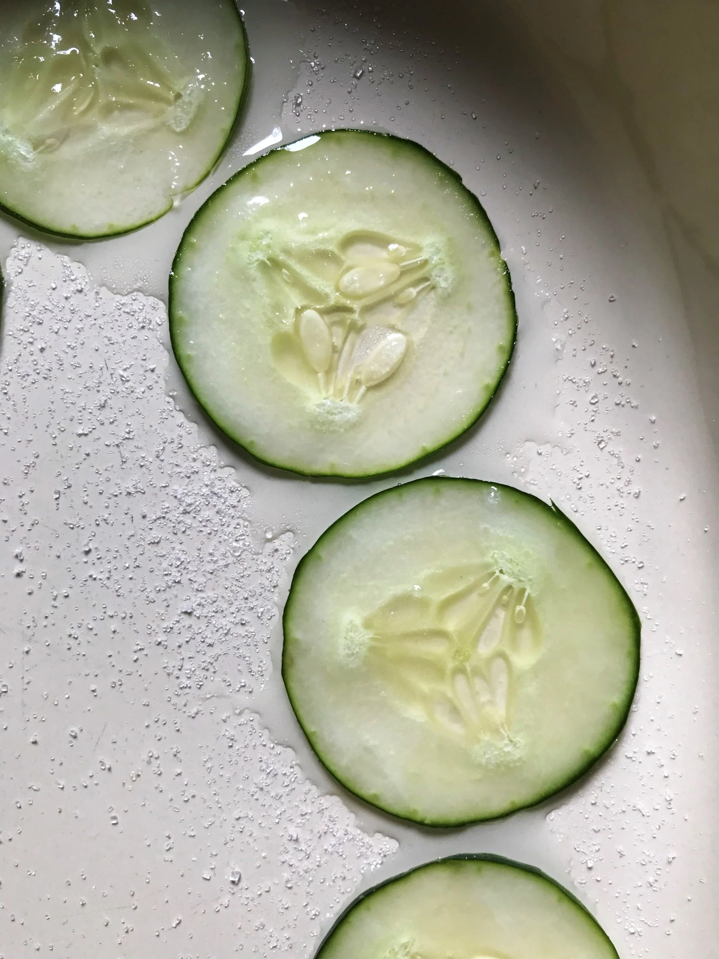 Cucumber slices macerating in sugar.