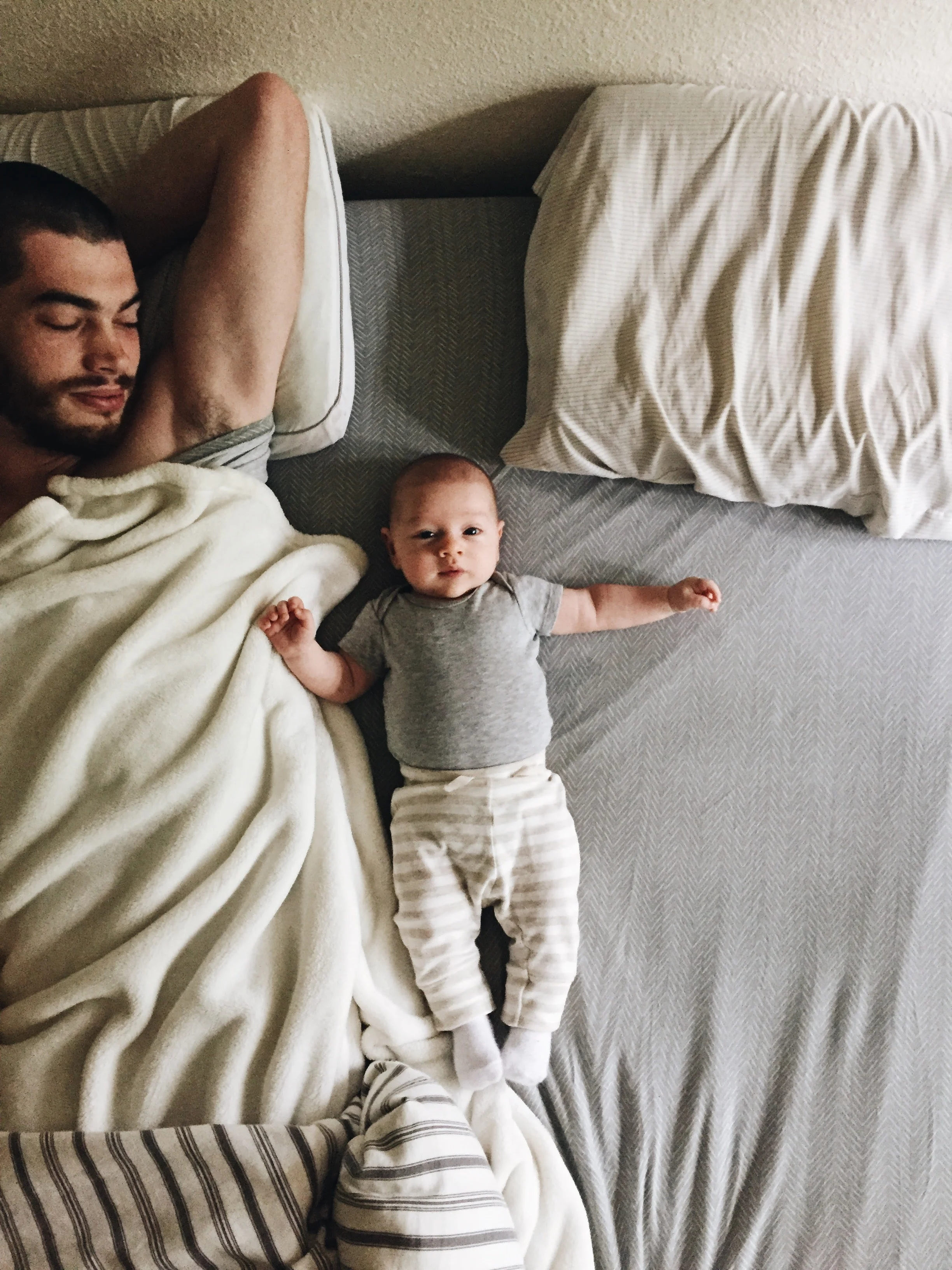 9.23.17 He's getting bigger but he still looks teeny tiny next to daddy in ourbig bed.