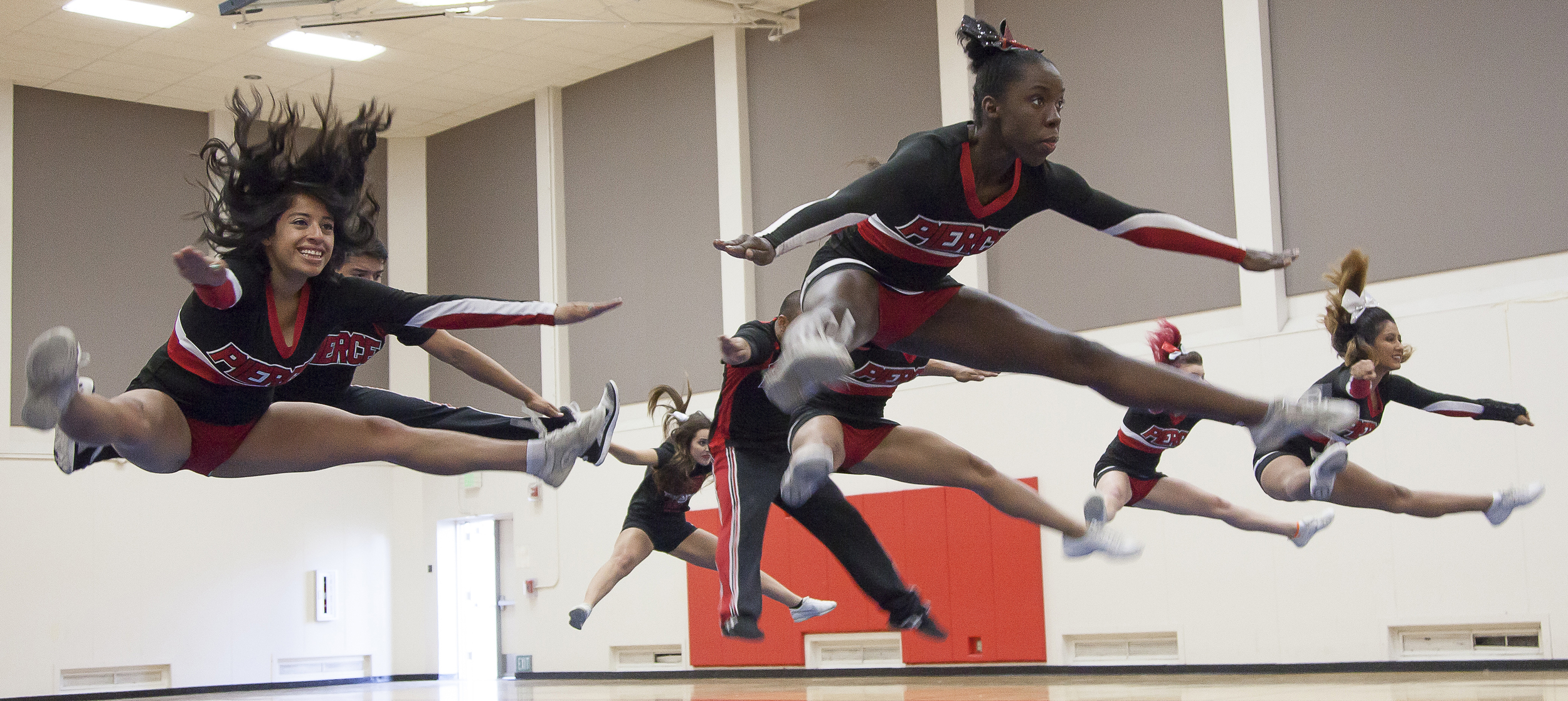  (From left-right) Dulce Rendon, Rushanda Duquesnay, Daisy Torres Barrera and other members of the Pierce Cheer Competition Team jump during a practice session in the North Gym on Sunday March 1, 2015. The jump is a part of the routine that will be u