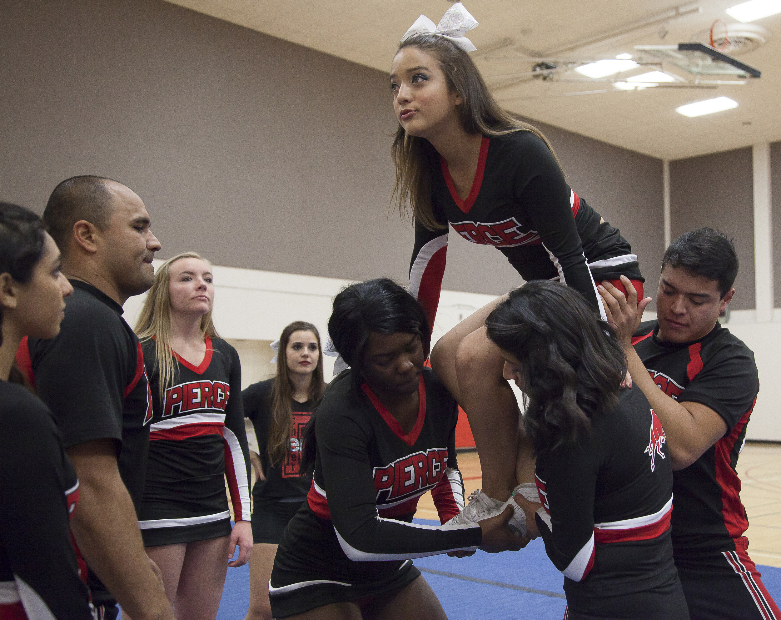  Vivian Herrera prepares to be lifted by Karlanda Duquesnay, Dulce Rendon and Jesus Guzman in a maneuver called a "full up", as other team members watch during a pracitice session in the North Gym on Sunday March 1, 2015. Woodland Hills, Calif.  Read