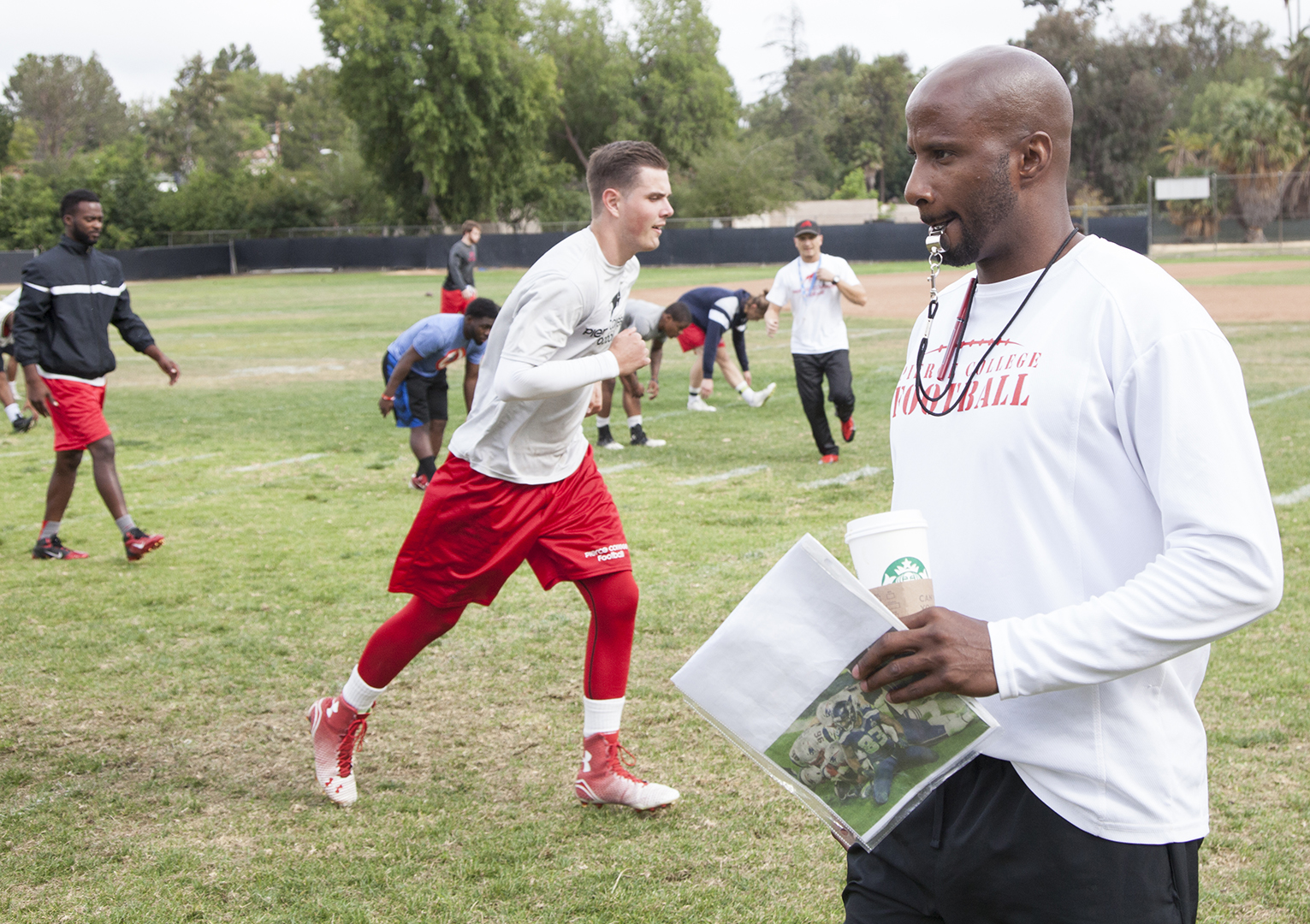 Defensive coordinator Torry Hughes leads the Pierce College football team in warm up drills during a spring practice and training session on Thursday, May 14, 2015. Woodland Hills, Calif. 