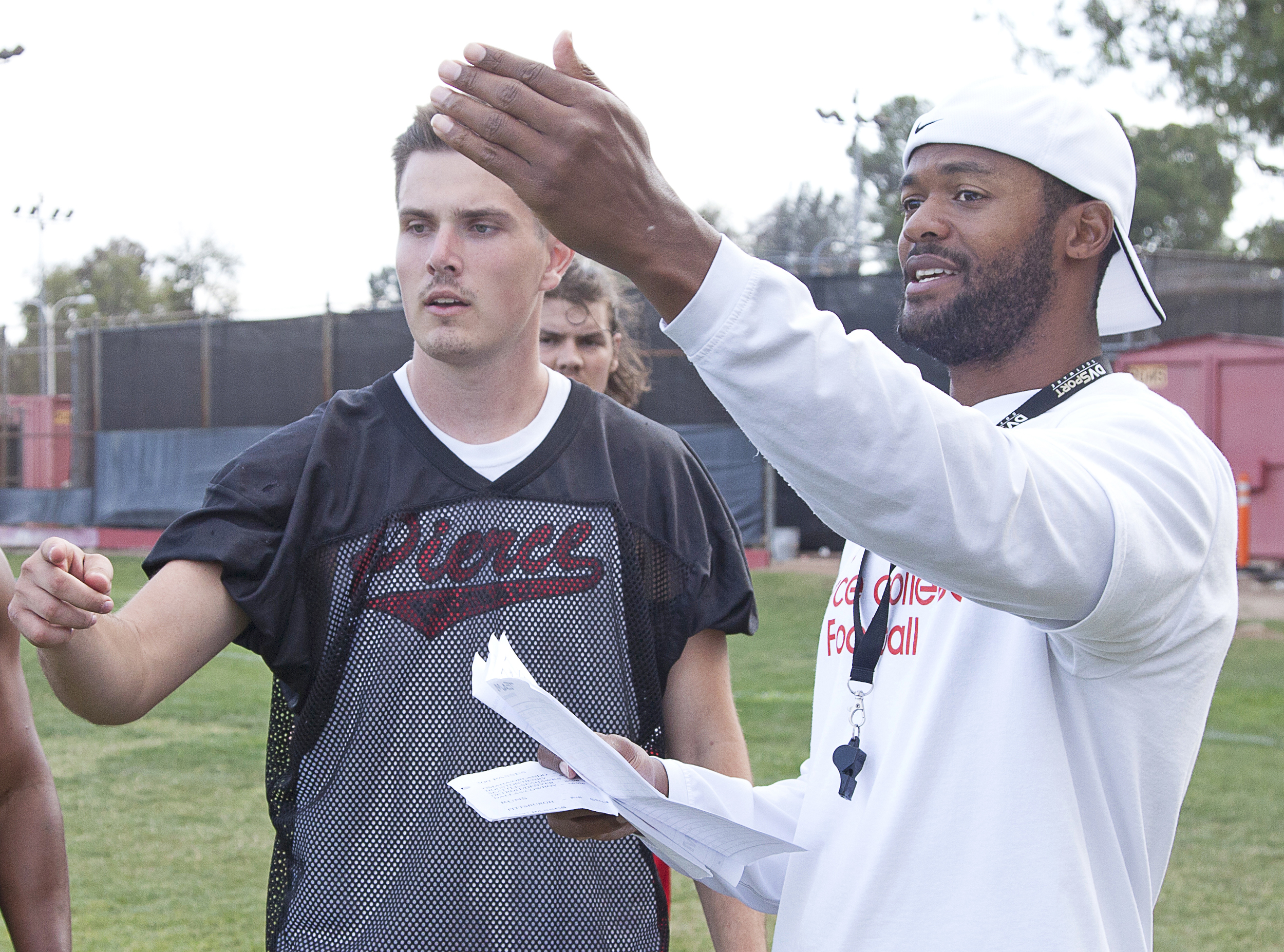  Sean Smith, quarterback for the Pierce football team, discusses a play with offensive co-ordinator Matthew Hatchette during spring practice on Thursday, May 21. Woodland Hills, Calif.&nbsp; 