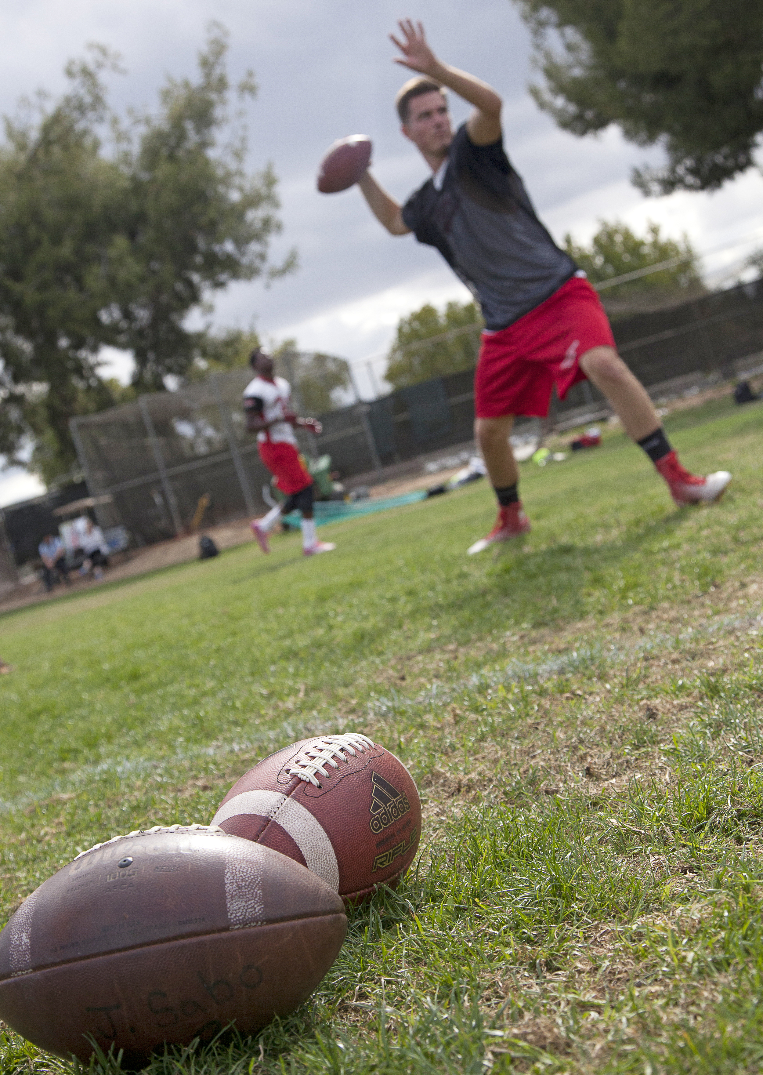  Two footballs lay on the field as quarterback Sean Smith performs throwing drills during a spring practice and training session on Thursday, May 21, 2015. Woodland Hills, Calif.&nbsp; 