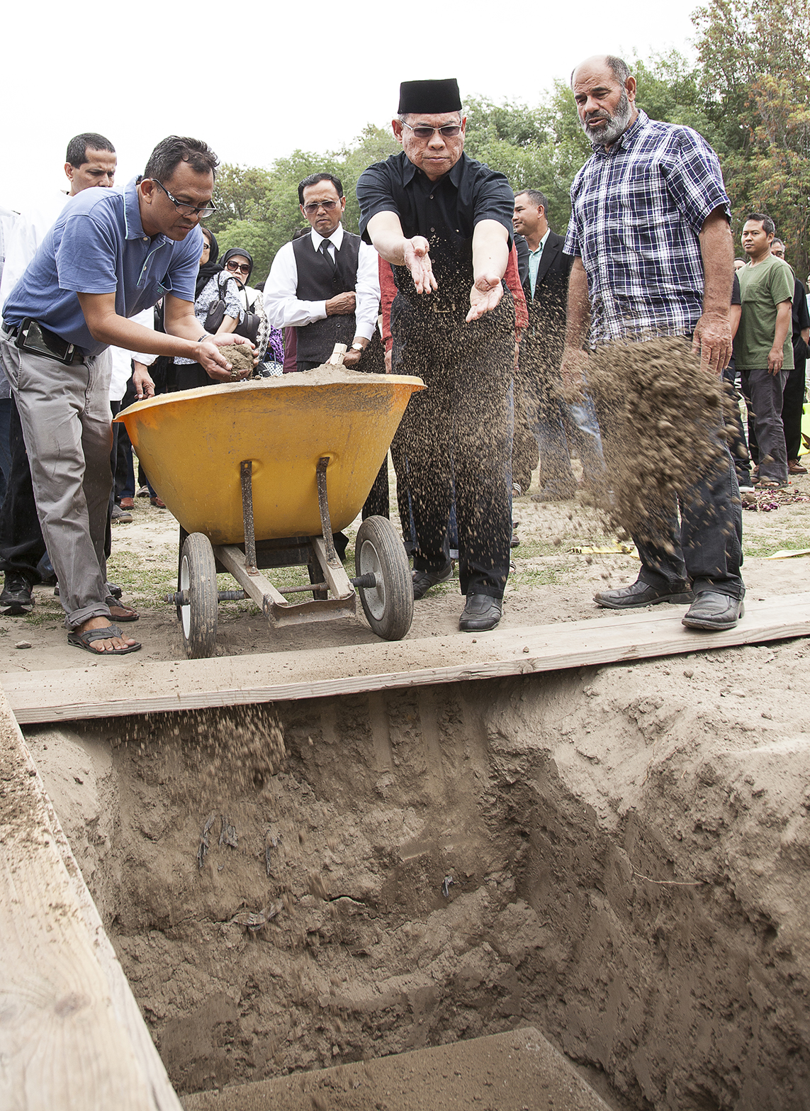  Mourners ritually throw dirt over my father's grave three times as they recite prayers during my father's funeral in Garden Grove, Calif. on&nbsp;Saturday, June 27, 2015 