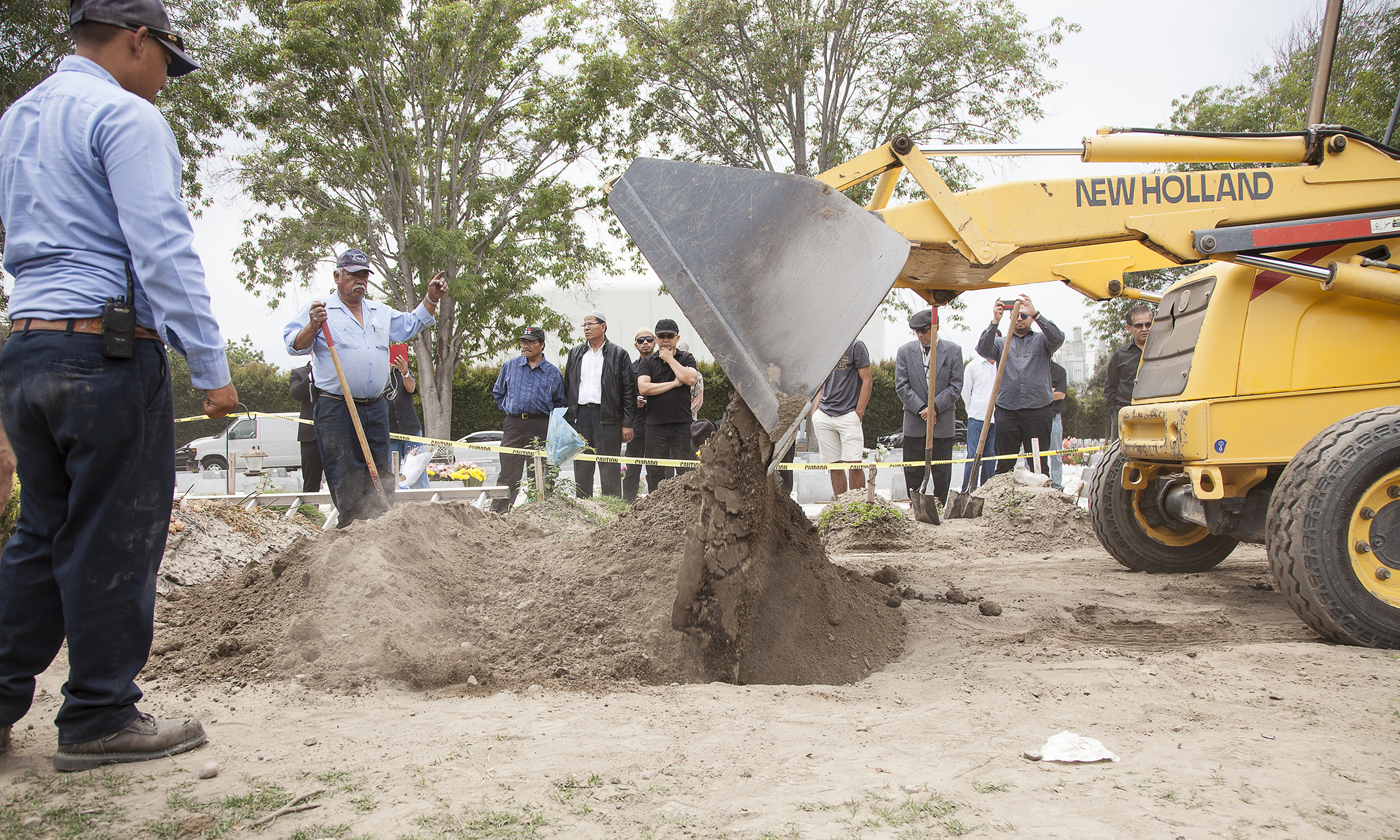  After lowering a concrete slab over my father's grave, a bulldozer pushes and fill's the grave with dirt on Saturday, June 27, 2015, completing the burial process. 