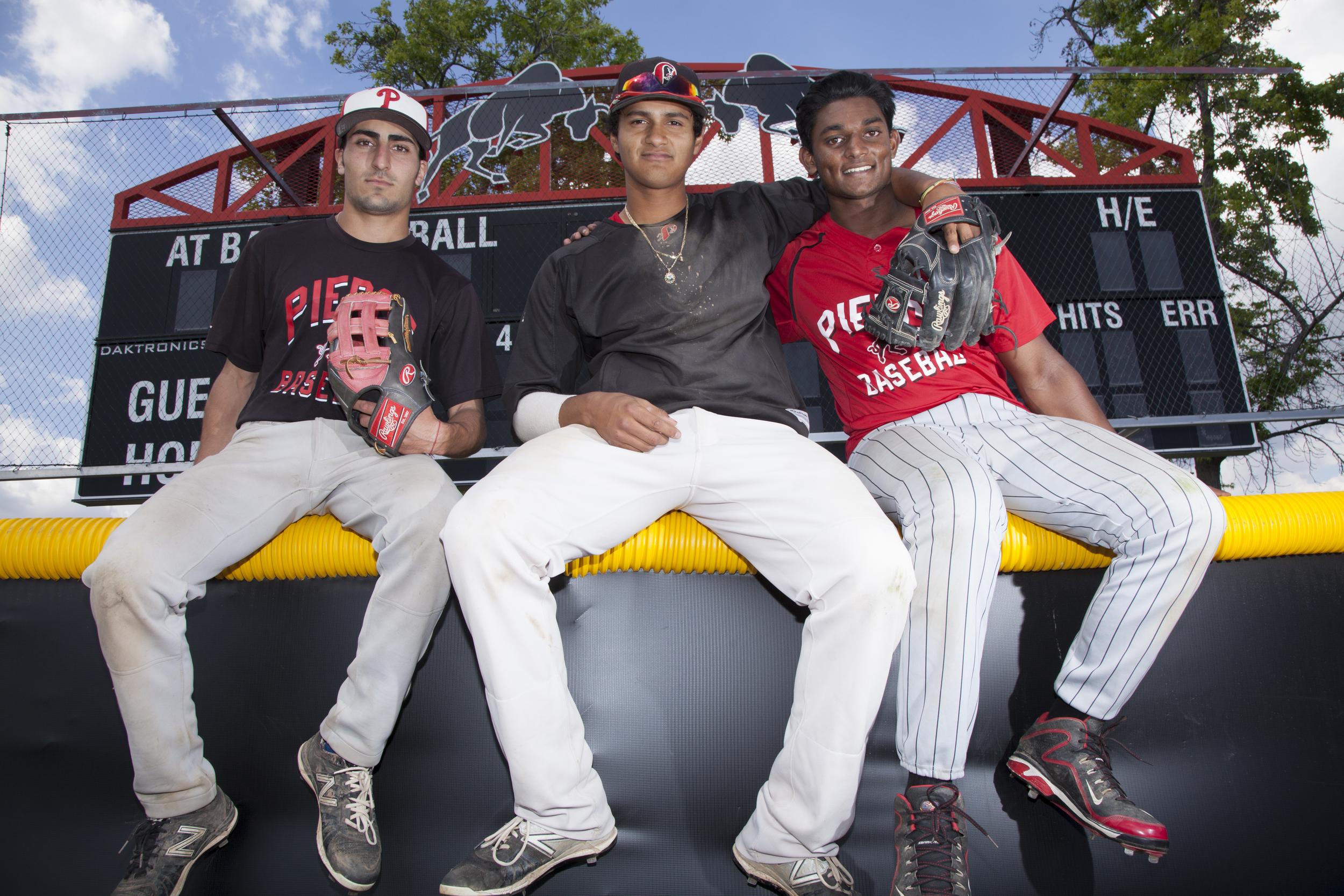  Trevor Dergazarian, Edgar Vela and Deion Fernando sit on top of the outfield wall of Joe Kelly Field in Woodland Hills, Calif. on Monday, April 11, 2016. 
