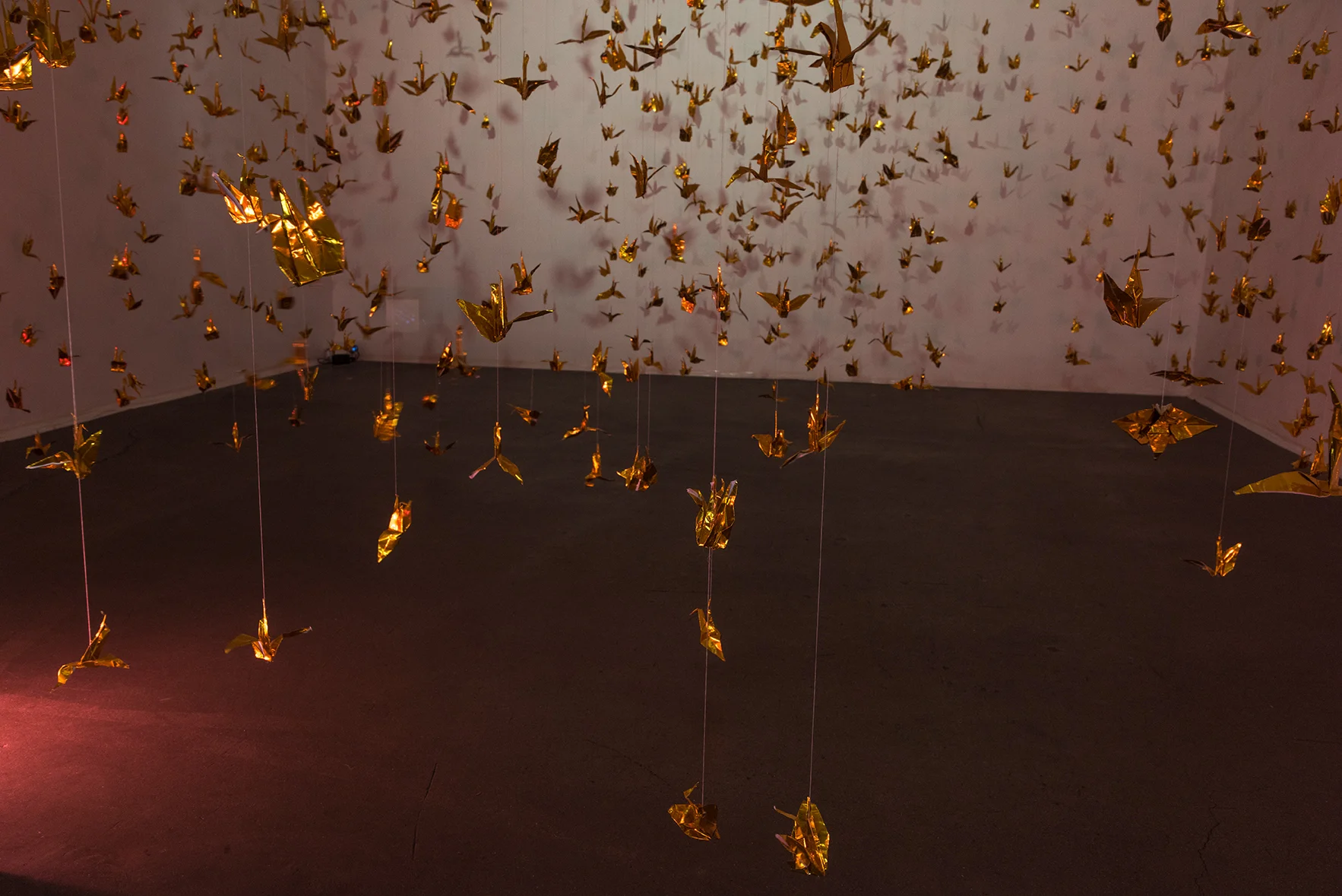 Isabelle Harada W=Fd , 2016 Variable dimensions 999 foil origami cranes, thread, mylar gels