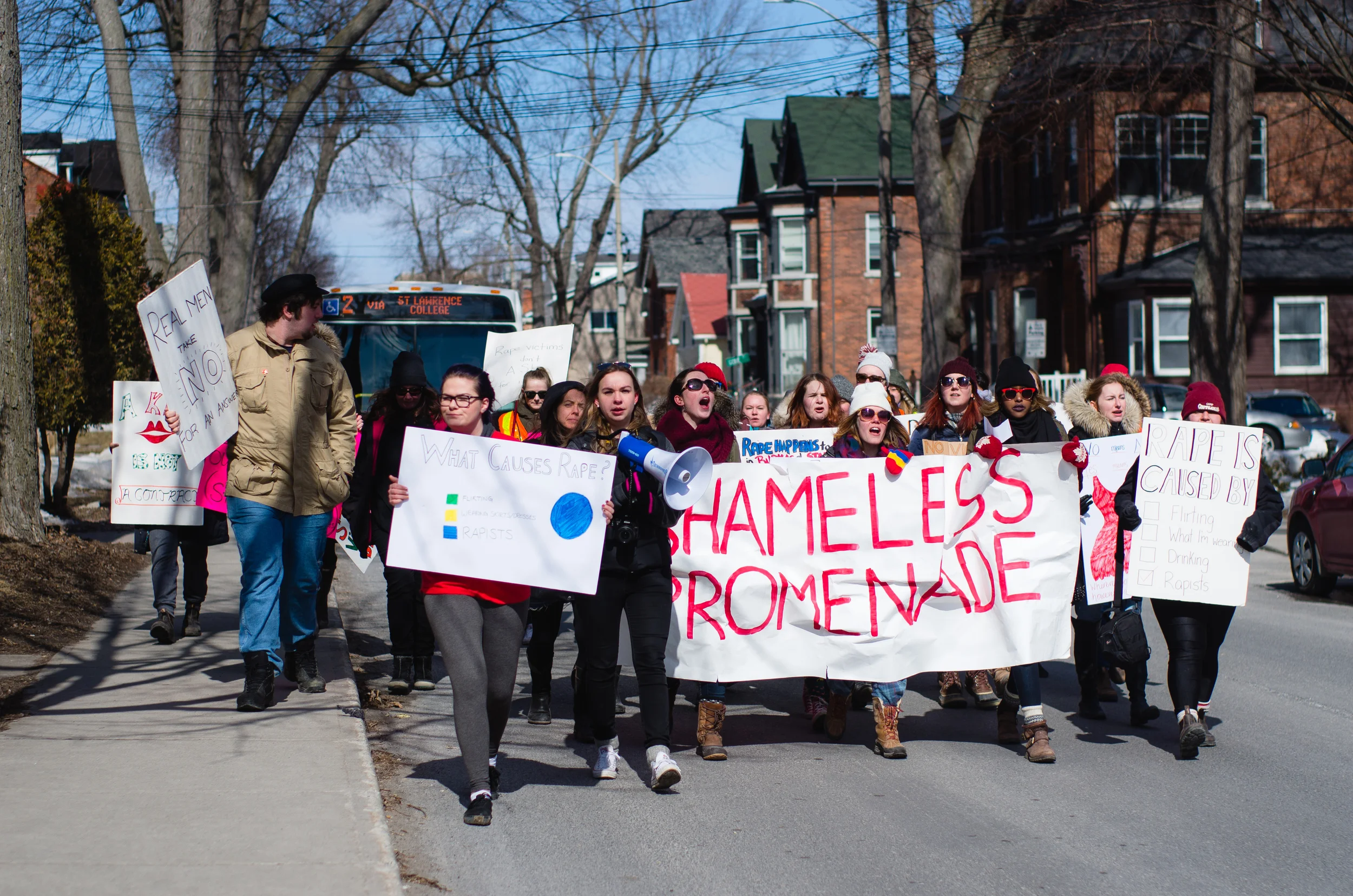 Led by organizer Montana Hauser (center, holding megaphone), marchers protest rape culture at the Shameless Promenade, formerly known as SlutWalk. "Shameless Promenade flaunts name change" (Queen's Journal )