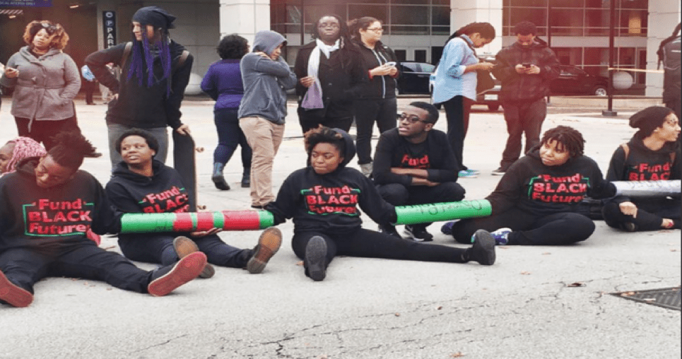   Charlene Carruthers, national director of BYP 100 (center) with other activists protesting the International Association of Chiefs of Police (IACP) Conference in Chicago in October of 2015. Photo Credit –    BYP 100 Twitter Page   