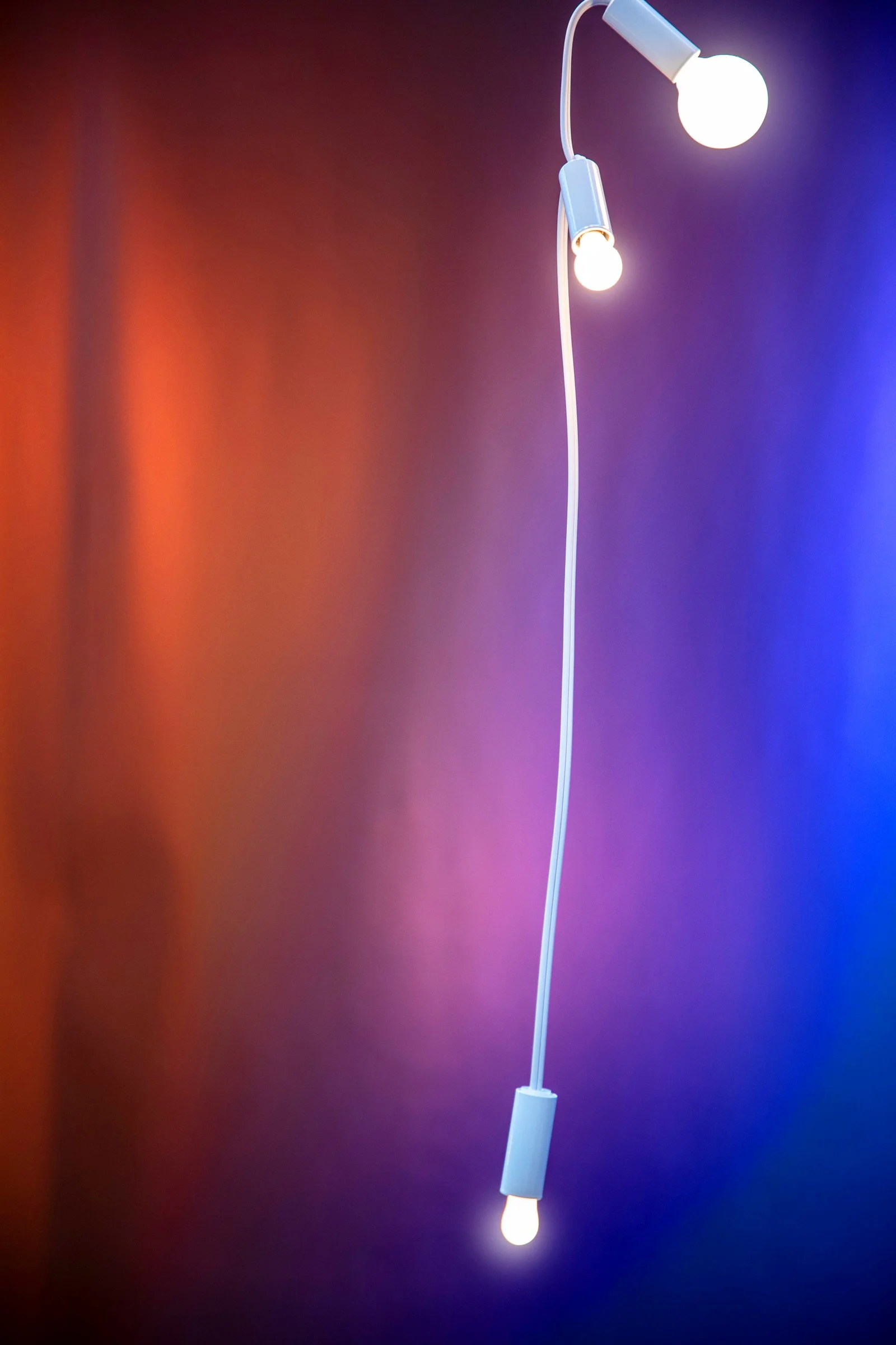 Minimalist pendant lights against a colorful background