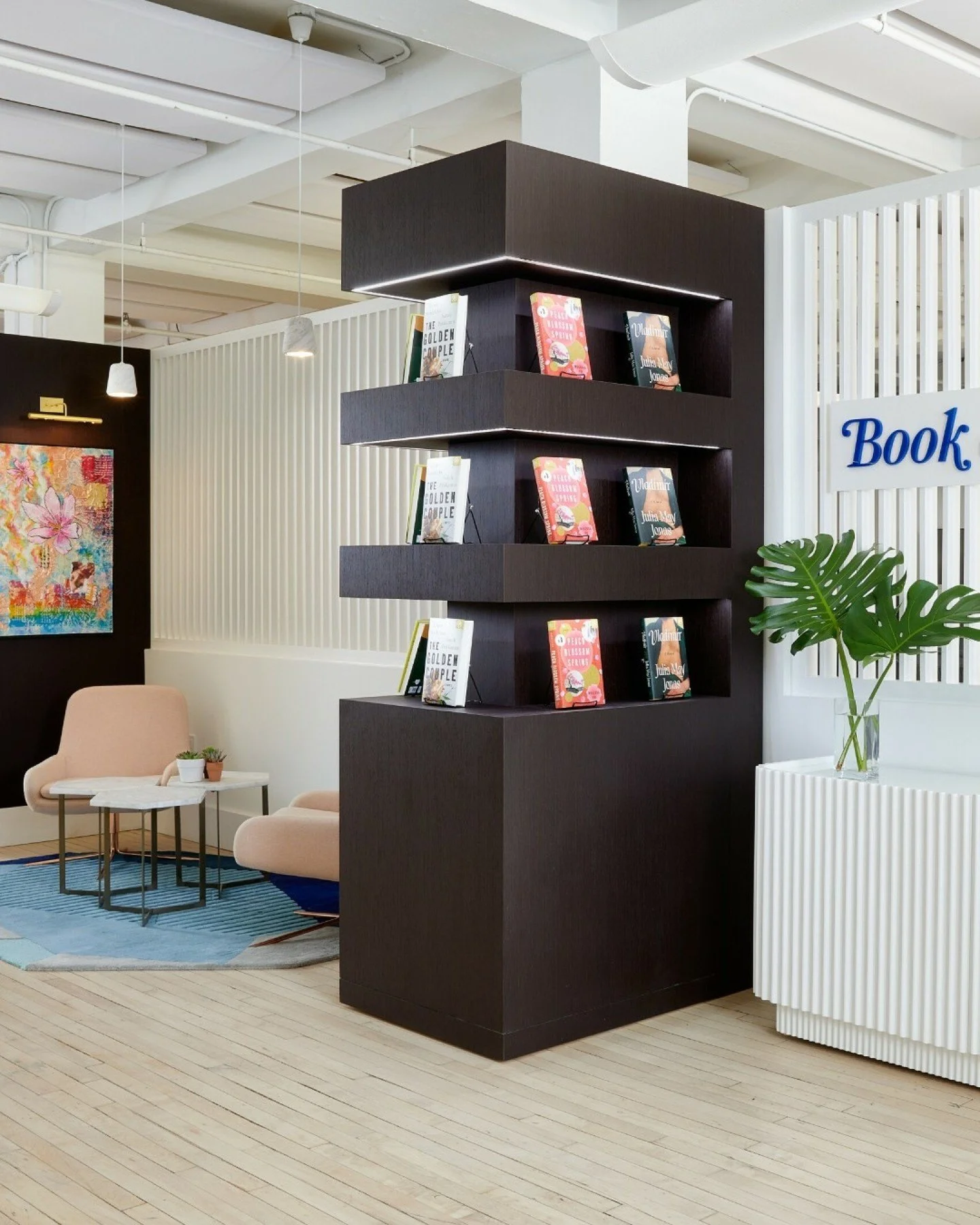Our design for the Book of the Month headquarters resonates deeply with their core mission of curated storytelling. Brand expression played a central role in the transformation, starting at the entry where a custom bookshelf sets the tone and evokes 