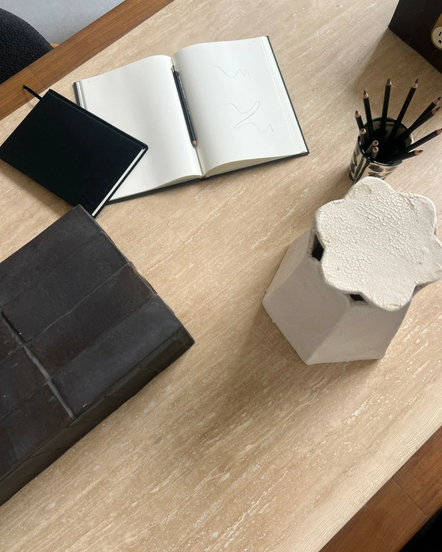 A closer look at our custom table for Smartflyer. Travertine surface, wrapped in rich walnut, grounded by sculptural black tile legs. Check out our Engaged Legs furniture on our website to learn more!