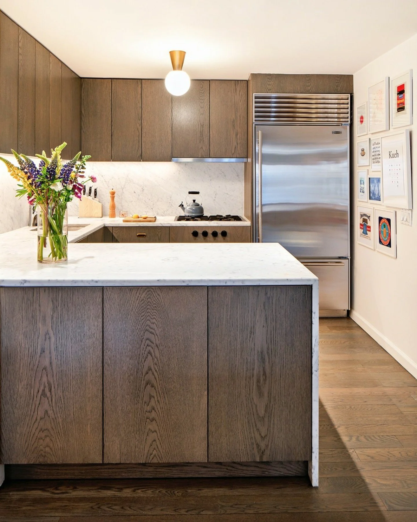 For this apartment renovation in Tribeca, we designed the kitchen as an anchor within the home, introducing custom oak cabinetry that ties seamlessly into the existing wood floors and surrounding architecture. Extending the existing countertop materi