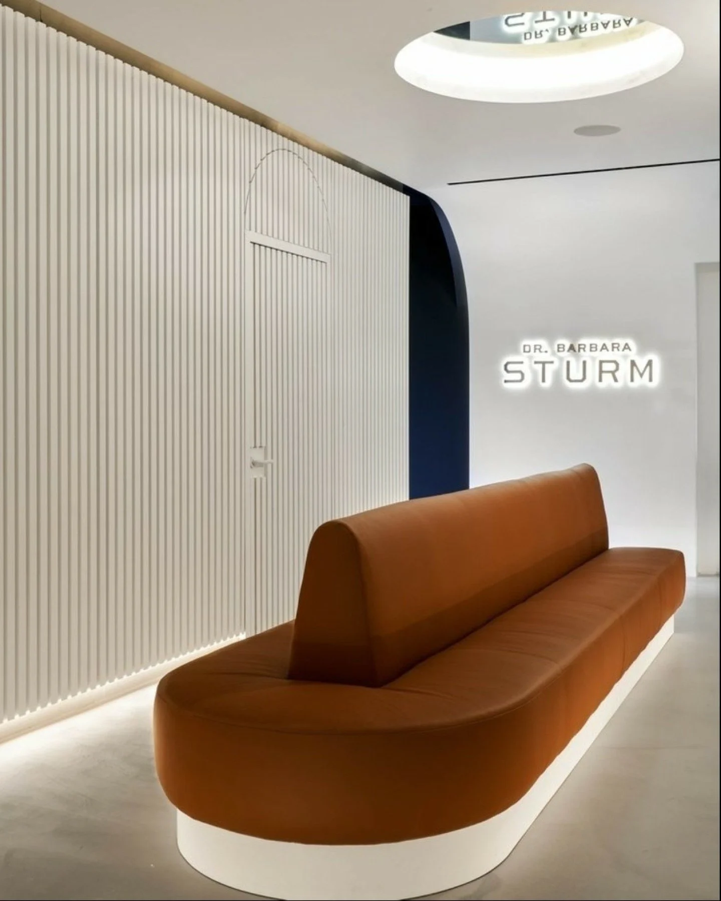 Throughout the Dallas location of  Dr. Barbara Sturm , a carefully layered palette of tan leather, concrete, brass, and light to dark neutral tones establishes a subtle spatial rhythm as clients move through each program. This progression from bright