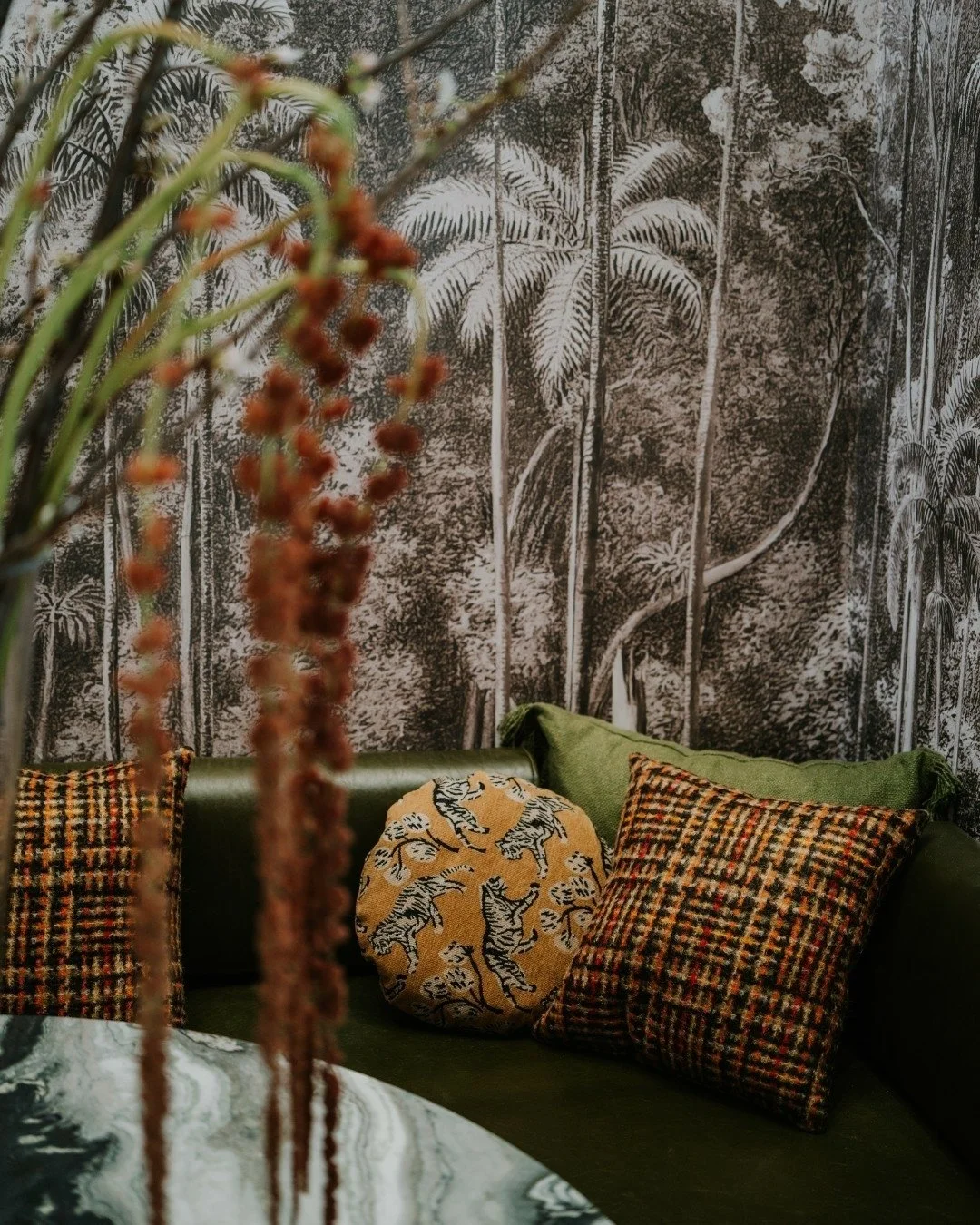 Nestled beneath the grand staircase at the SmartFlyer Penthouse, this custom banquette is paired with a custom mural by Milton &amp; King, creating an intimate and visually striking moment.