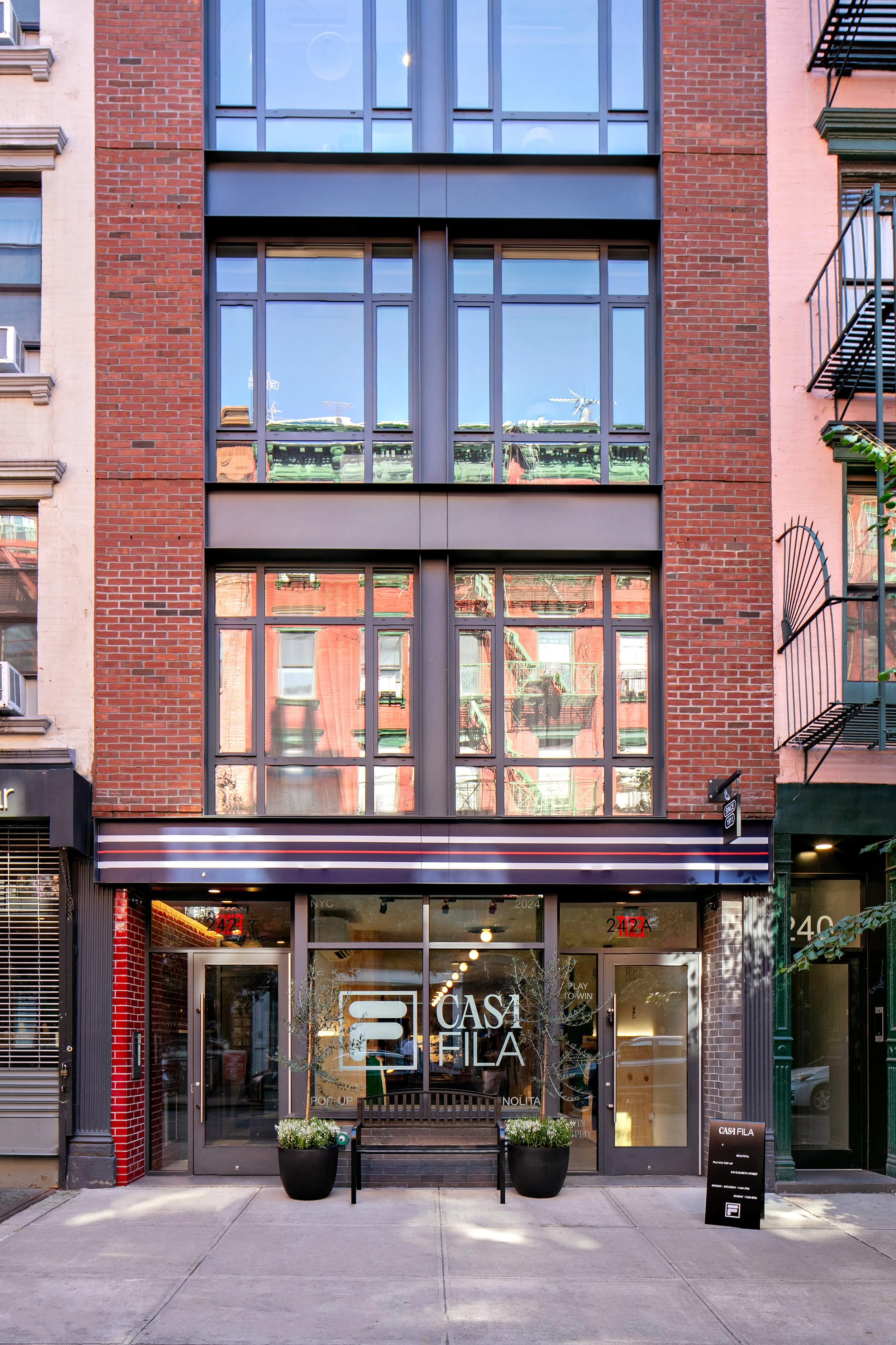 Exterior view of a building in New York City with large windows and a brick facade, featuring the "CASA FILA" signage on the entrance.