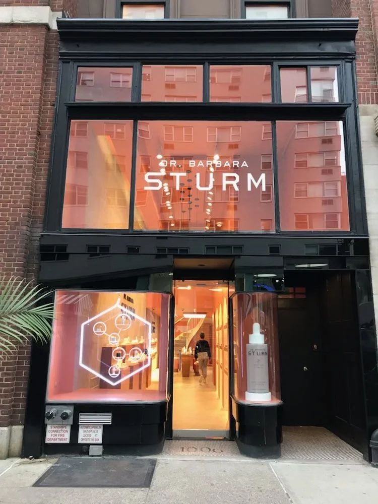Storefront of Dr. Barbara Sturm with orange-tinted windows and displays.