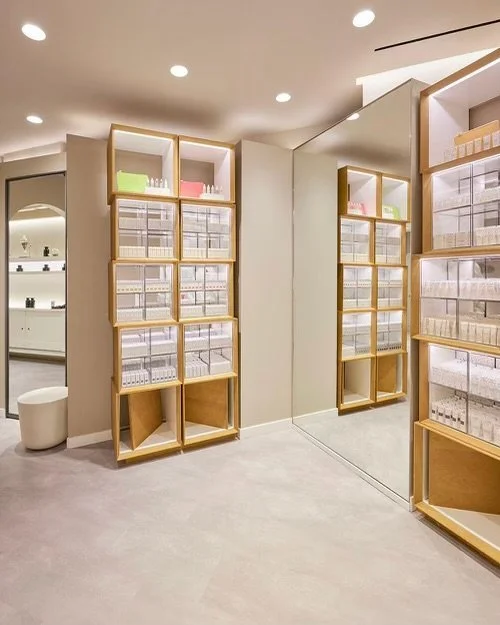 Modern cosmetic store interior with wooden shelving and mirrored wall.