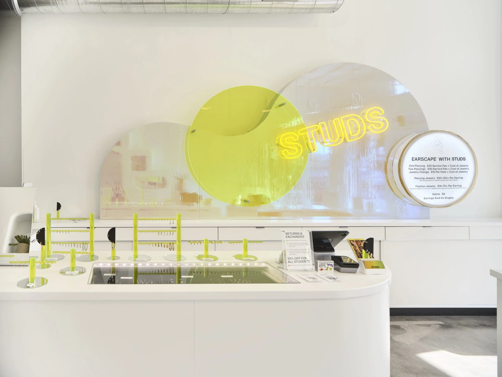 Trendy store interior with neon sign, jewelry display, and information board