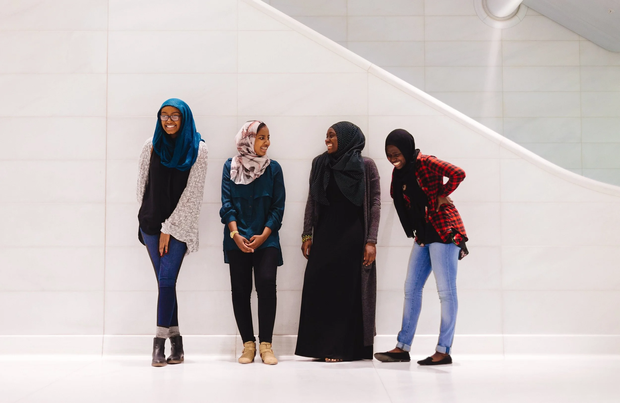 NYU students Bayan Abubakr, Fadumo Osman, Isatou Daffeh, and Mariyamou Drammeh share a laugh in a train station in New York City. Photo by Emilio Madrid-Kuser
