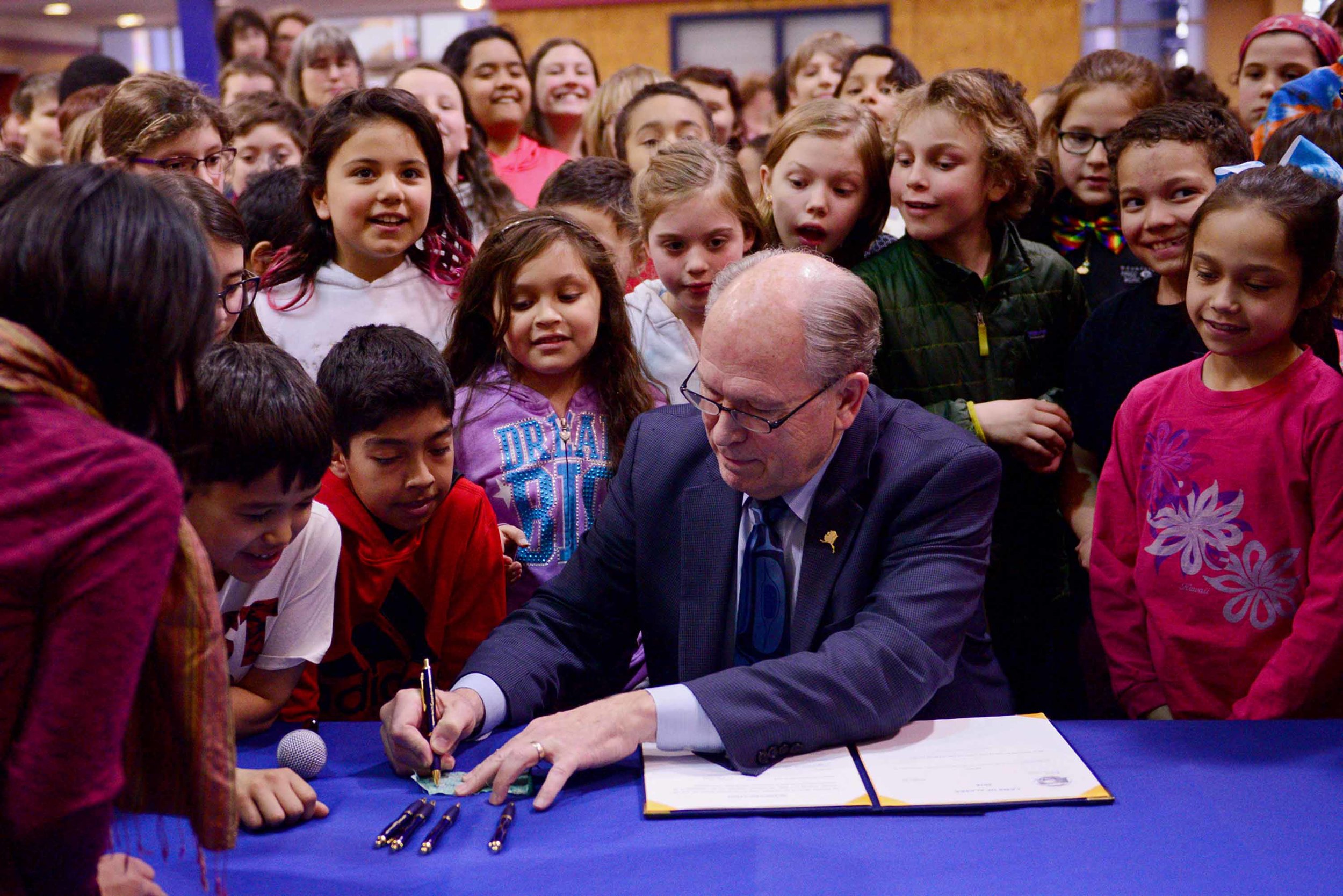 In Juneau, Harborview Elementary School students crowd around Gov. Walker as he signs House Bill 287, allocating $1.3 billion to early fund Alaska’s schools for two years. May 3, 2018. 