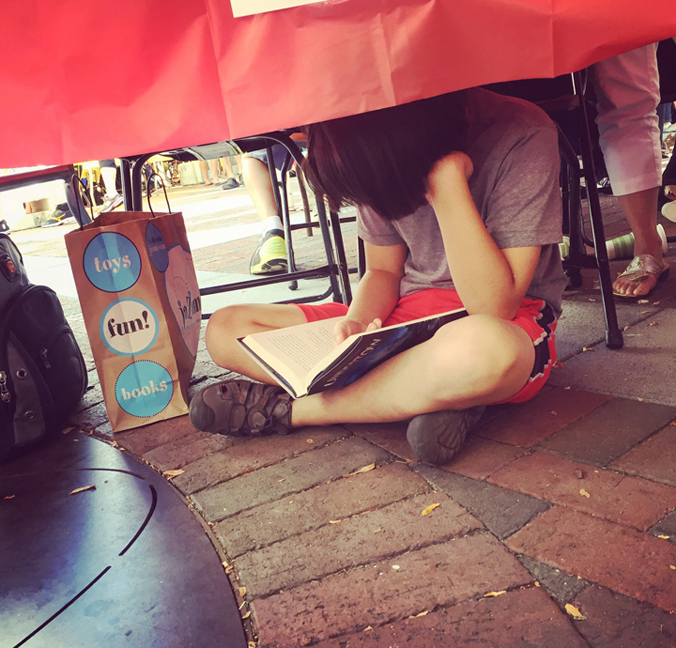 Jamie (Dennis & Melissa's son) reading under the table 