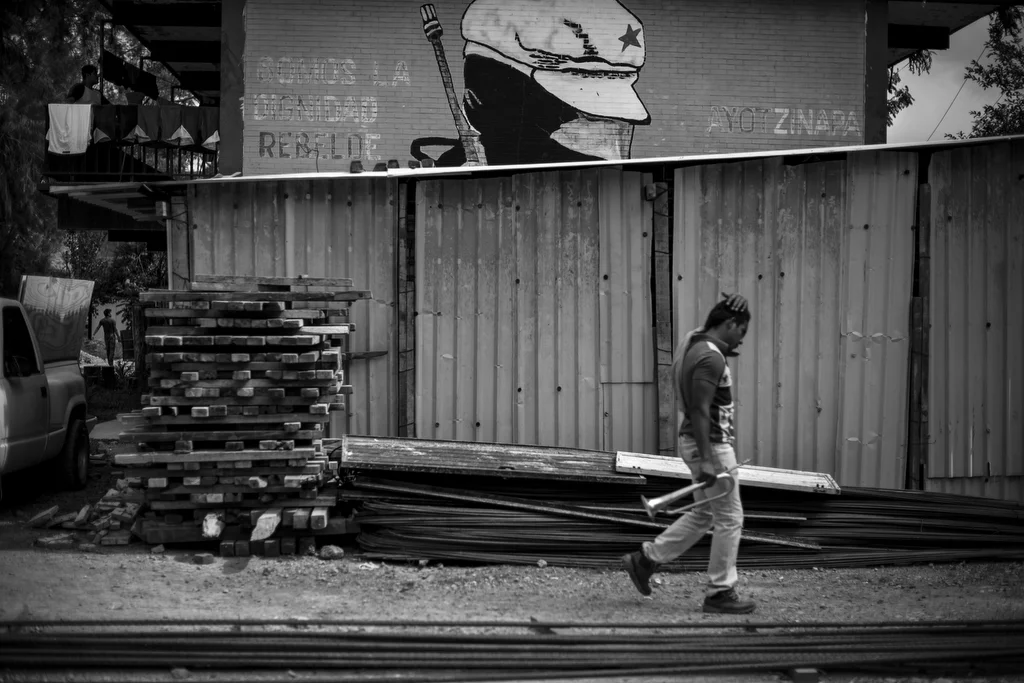  AYOTZINAPA, MEXICO - NOVEMBER 13: A student from the Ayotzinapa normal school walks past one of many revolutionary themed murals at the school that says, "We are rebel dignity," on November 13, 2014 in Ayotzinapa, Mexico. Forty three students from t