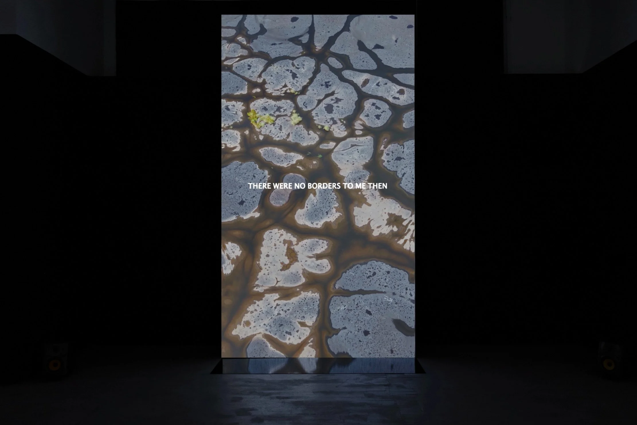 3.5 metre tall free standing projection of a 6:36 minute film, All That I Touch I Change, with sound and black mirrored acetate