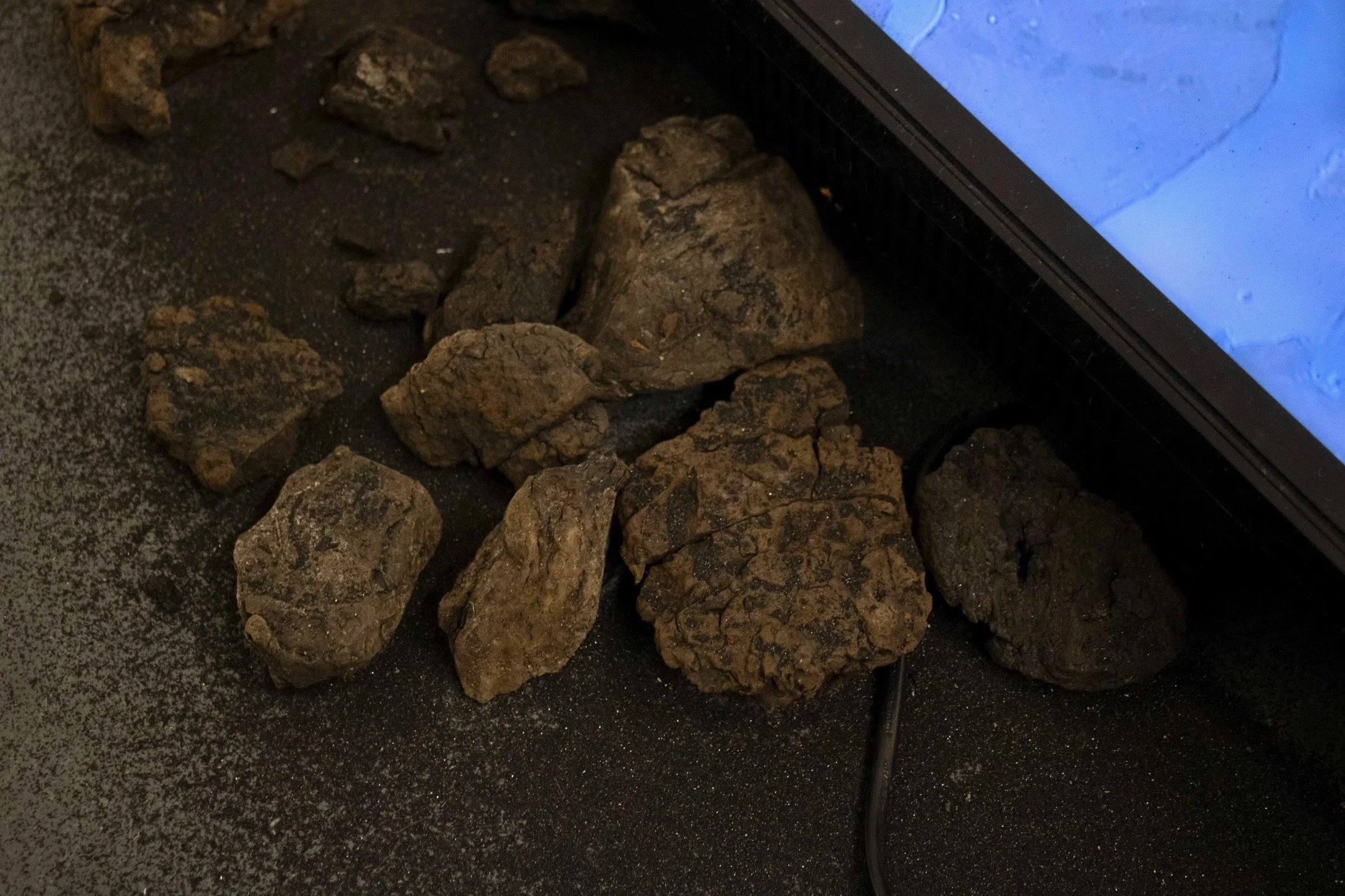 Close up of Installation of So Will I Turn Her Virtue Into Pitch featuring sand and pitch from the pitch lake in Trinidad & Tobago