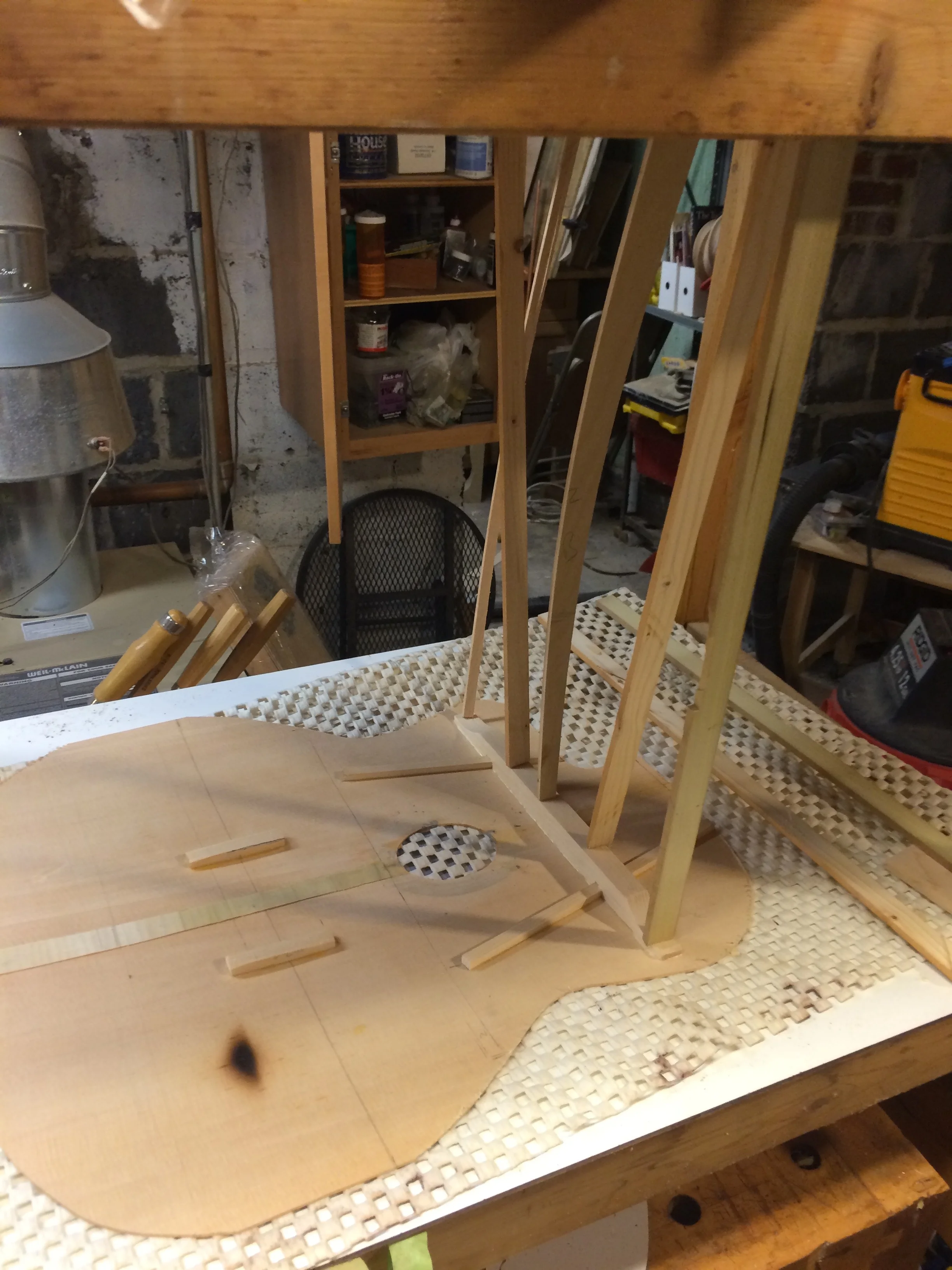 I glued the top braces on using an improvised go-bar deck built from an old Ikea kitchen cart. I wasn't sure how to get a proper radius dish for the bottom and being a cheapskate couldn't bear the idea of shelling out $80 on eBay for a CNC milled one. I took a sheet of masonite and drilled a hole in the center and then put a bolt and washer through the hole and tightened it down creating a dished surface. The gypsy top isn't really a dome anyway but the system seemed to work pretty well. I used ripped pine and maple sticks of various lengths as the go-bars. You get a really good view of the charred pliage in this photo. I flooded that with thin super glue hoping that that would help strengthen what must be somewhat compromised wood fiber.