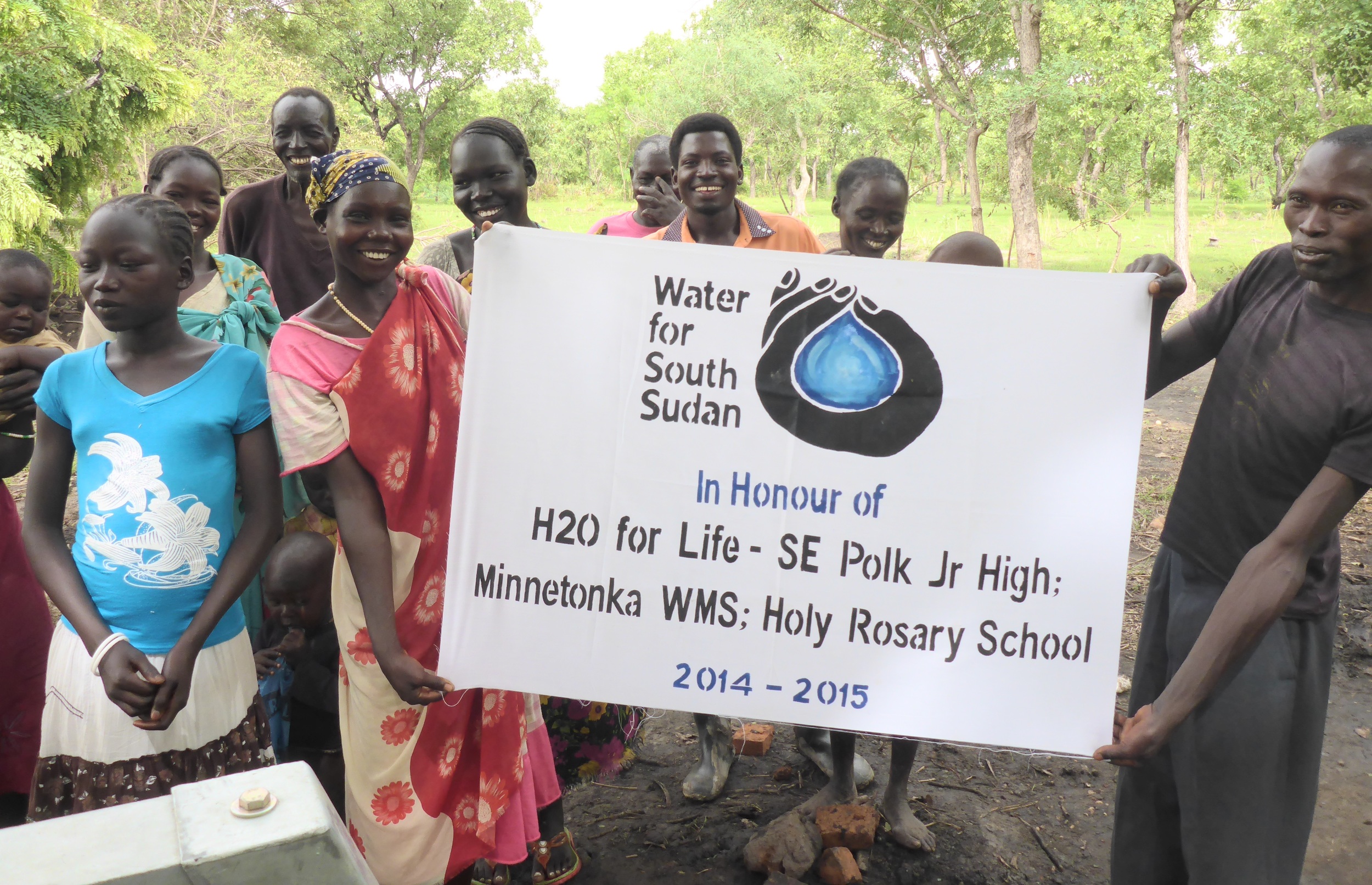 Villagers in Achuirdit, western bahr el ghazal state, proudly display well sponsorship banner.