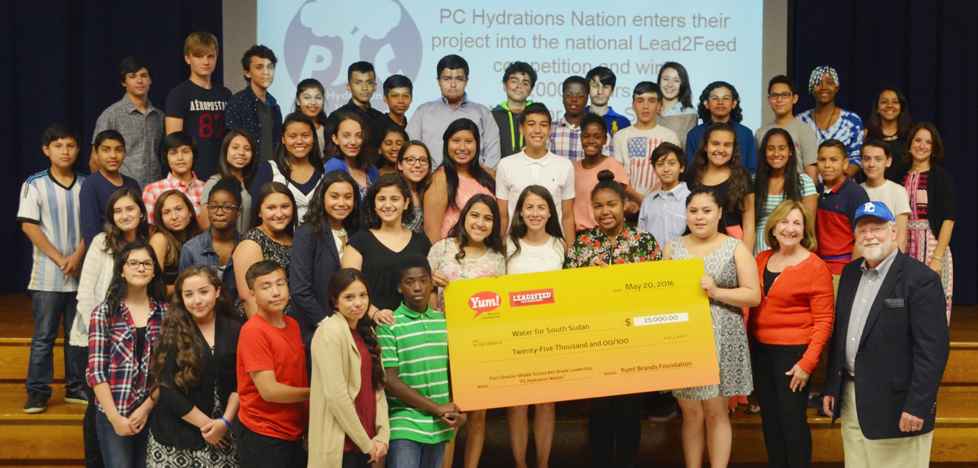 port chester middle school students present a check for $25,000 to wfss board member jack mckelvey (far right) as part of their lead2feed award.