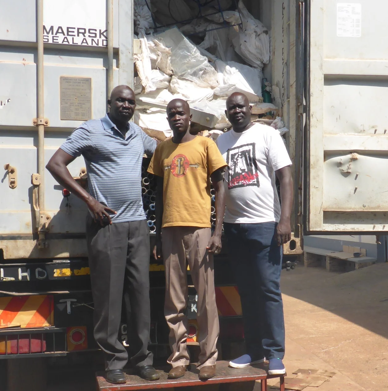 wfss country director ater thiep, hygiene manager mathew akuar and assistant country director aj agok with loaded supply truck in kampala