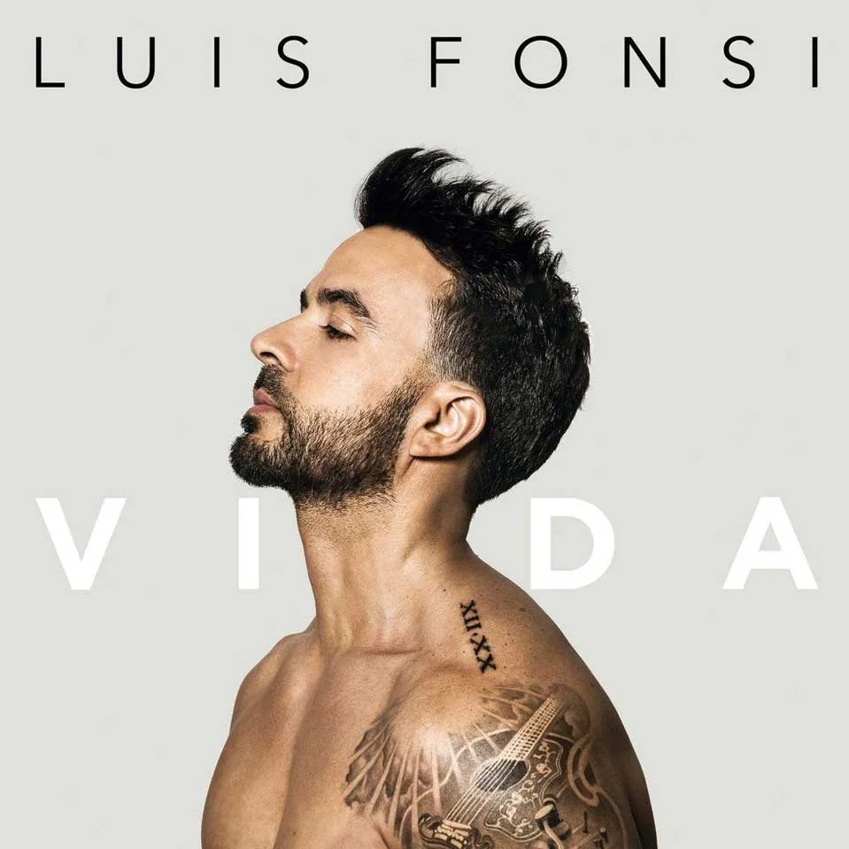 Album cover featuring Luis Fonsi with eyes closed, shirtless showing tattoos including a guitar on his shoulder, and text 'Luis Fonsi Vida' in black and white.