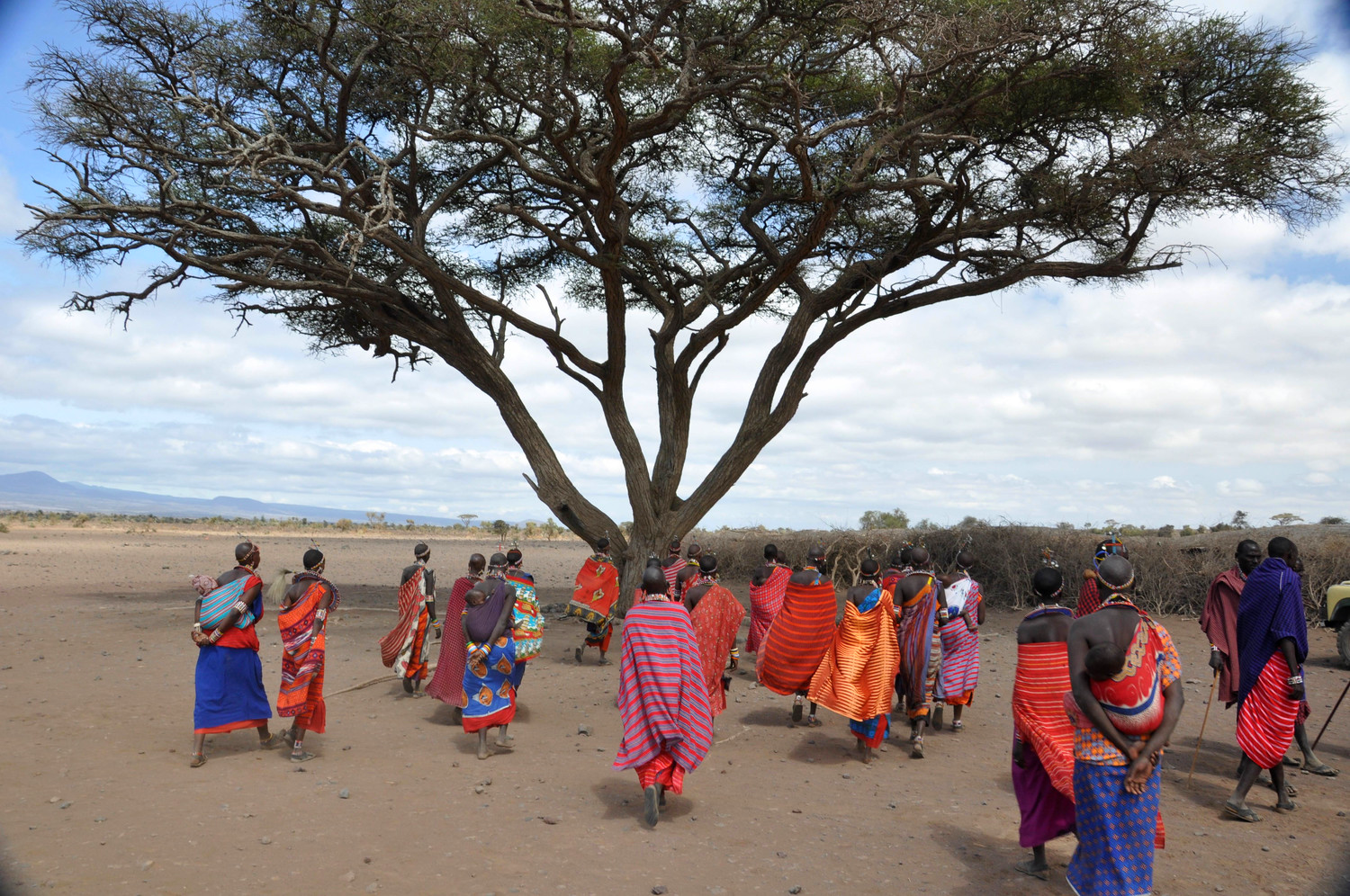 The Gathering, Ambosoli Kenya This image consistently brings back vivid memories of a Maasai village I visited on the outskirts of Amboseli, Kenya. I love the juxtaposition of the vibrant colors the villagers were clothed in with the starkness of the landscape in this very dry region situated in the rain shadow of Mt. Kilimanjaro.