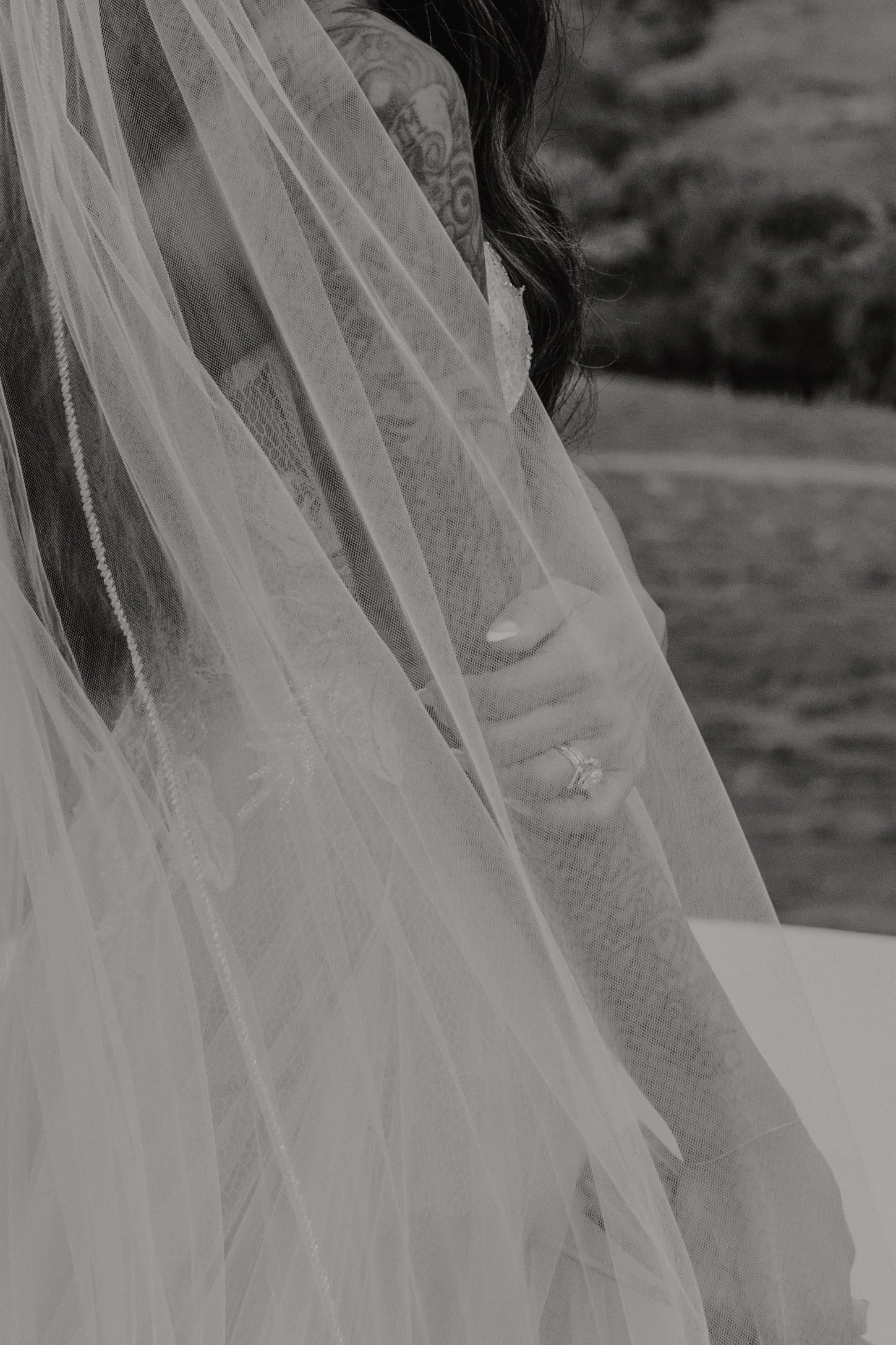 Bride wearing a Berta wedding gown with lace and tulle fabric and showing a beautiful wedding ring designed  by Liten Studio.
