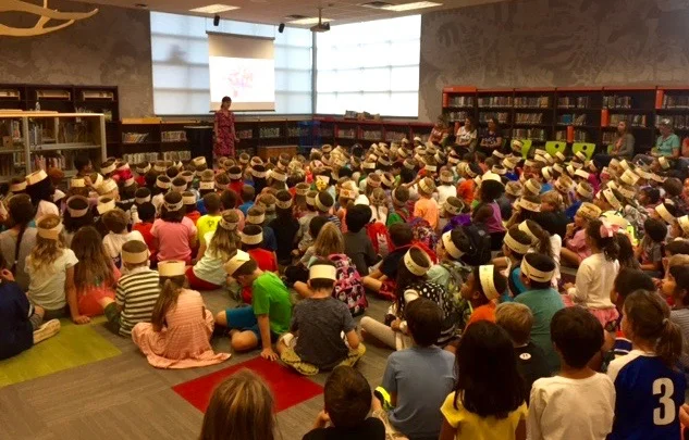 Three hundred kids wearing crowns they made for the event. Each kid wrote "Fantasmagory" on their crown. 