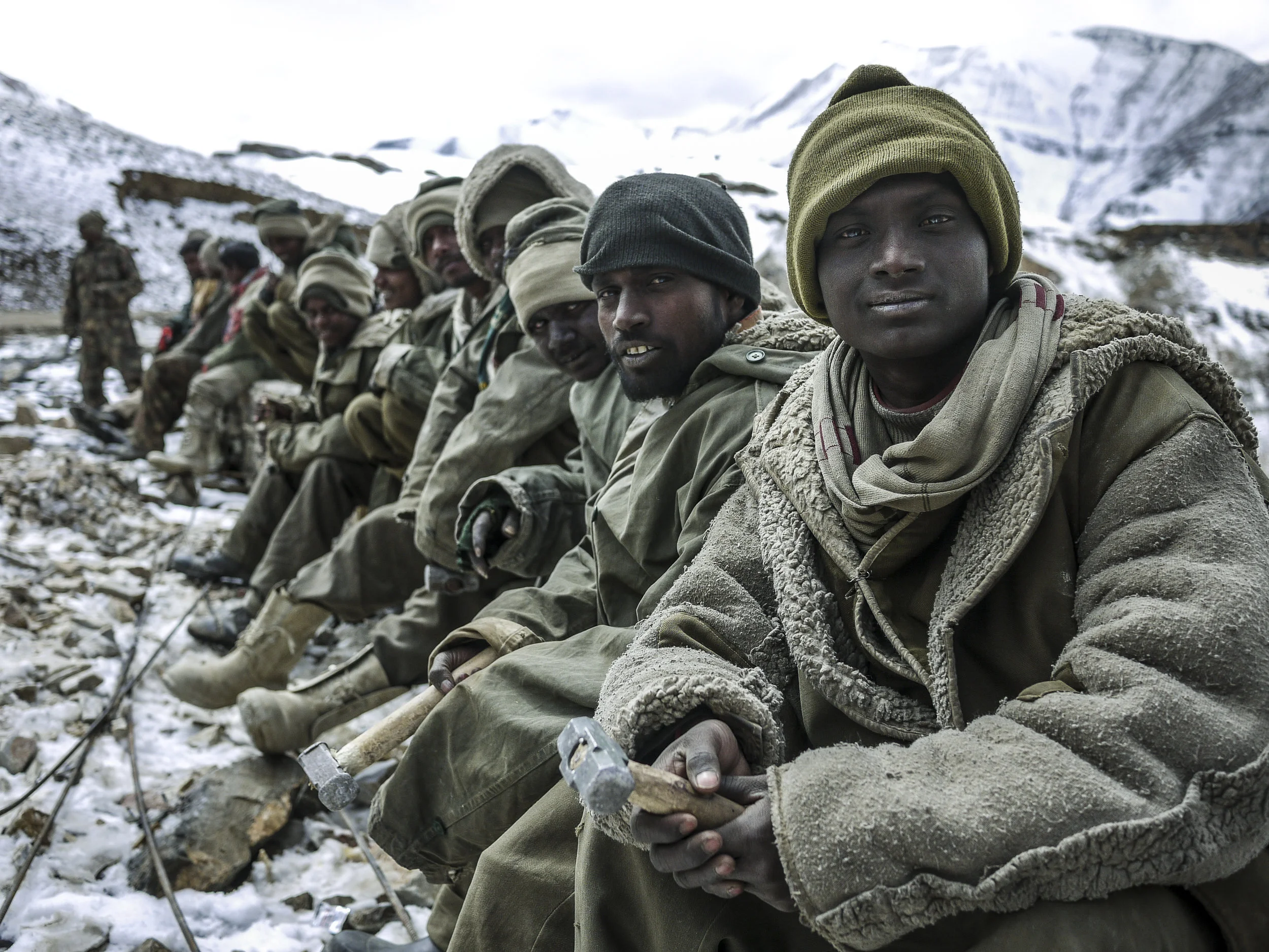 Bihari laborers line up for a break with their rudimentary tools in hand.