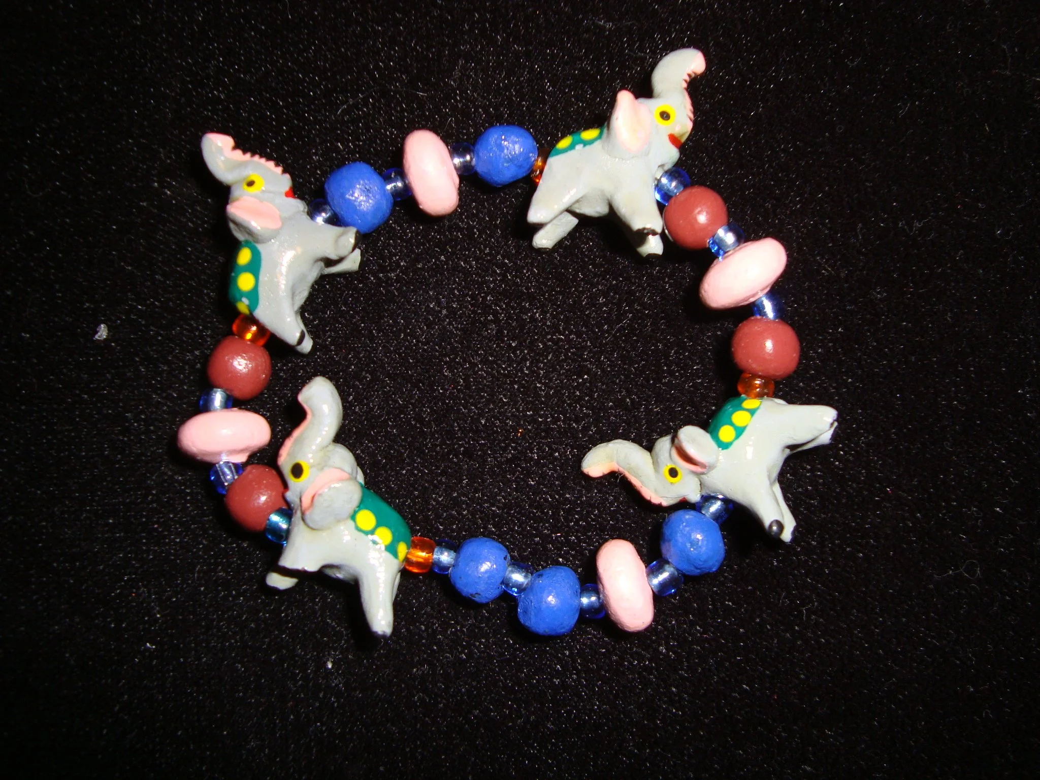 Colorful beaded bracelet featuring elephant-shaped charms on a black background.