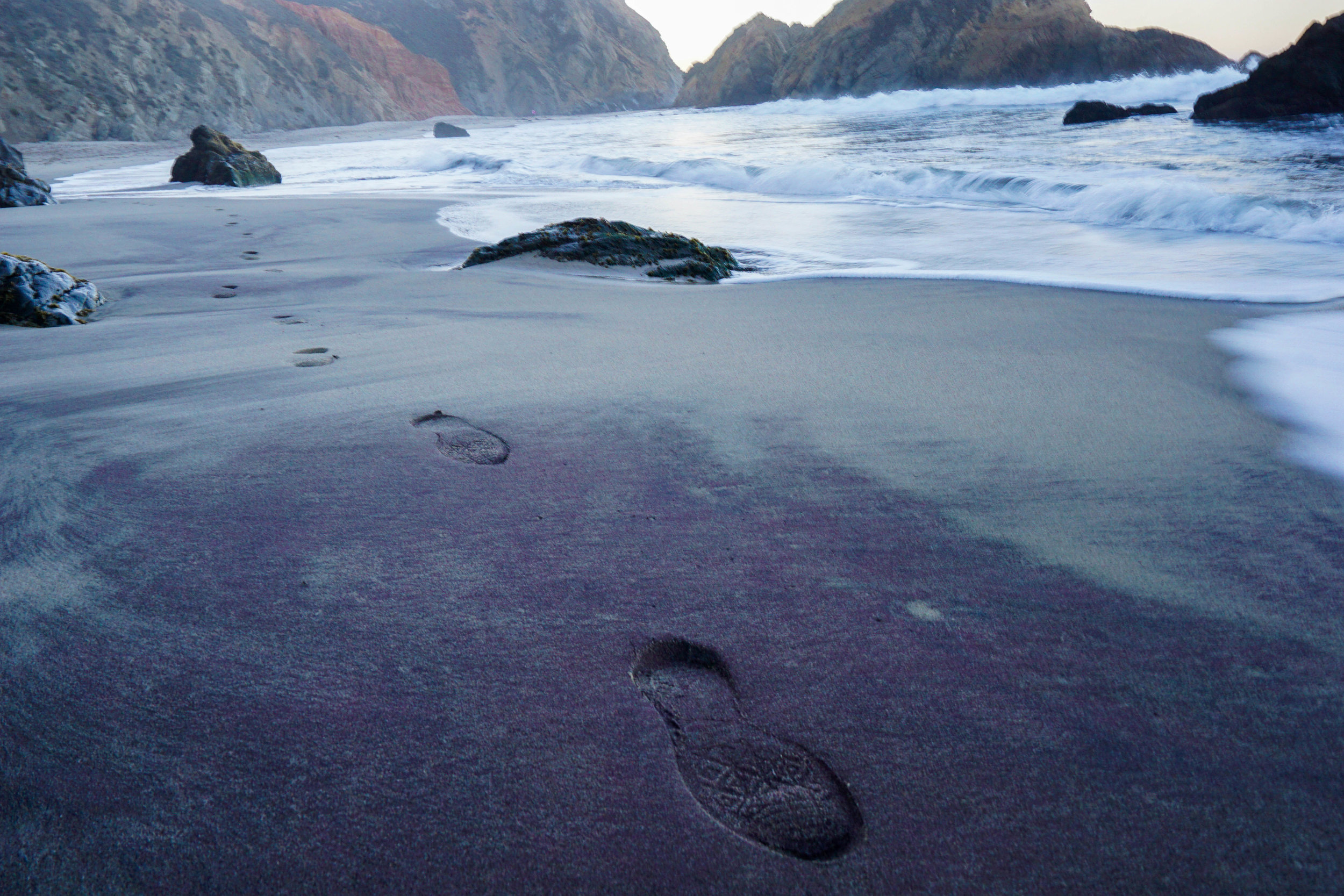 Minerals wash from the cliffs during the frequent rains, leaving purple streaks along the sandy shore.