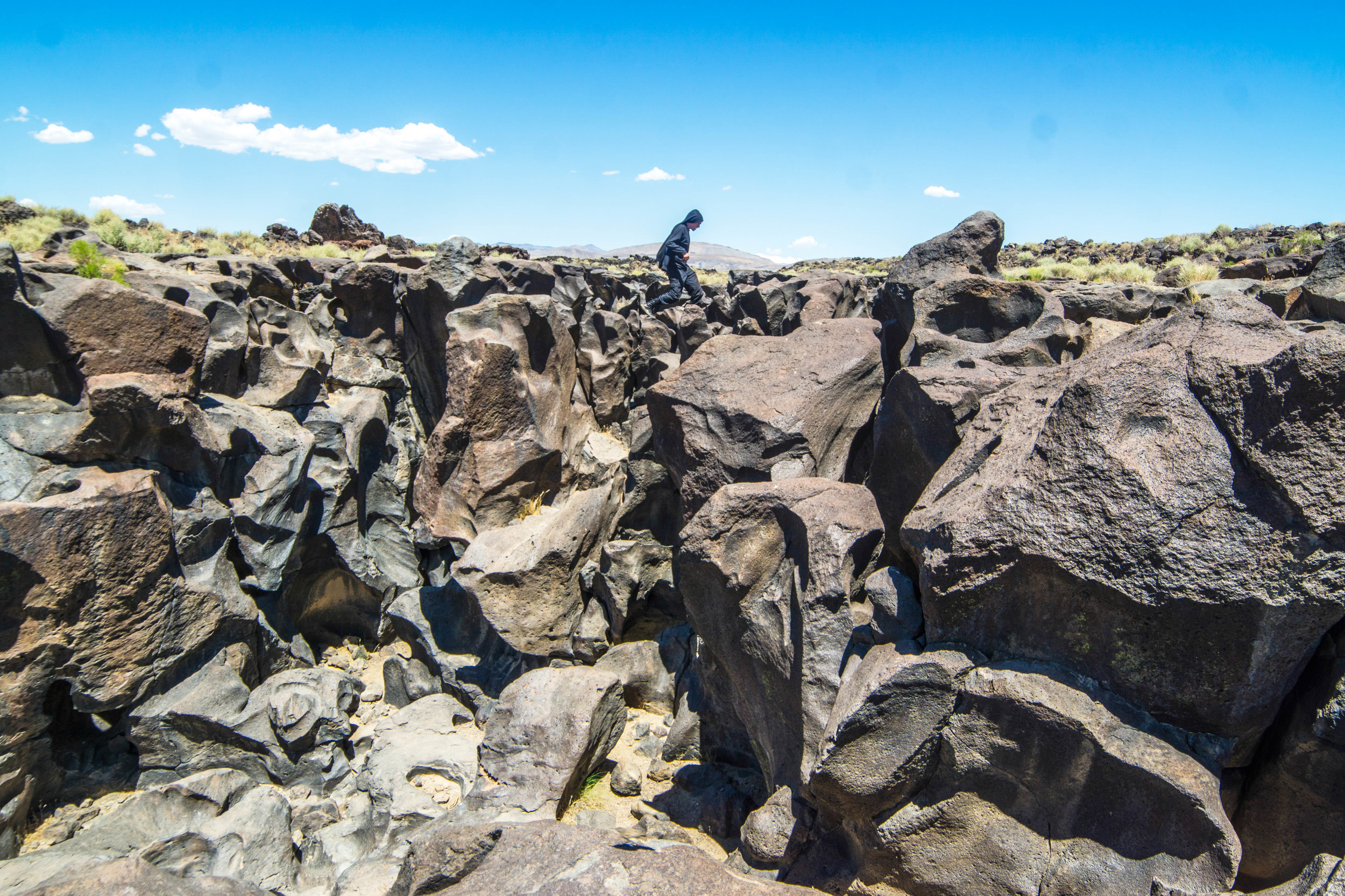 We briefly hop along the hardened magma before accepting defeat beneath the mid-afternoon desert sun.