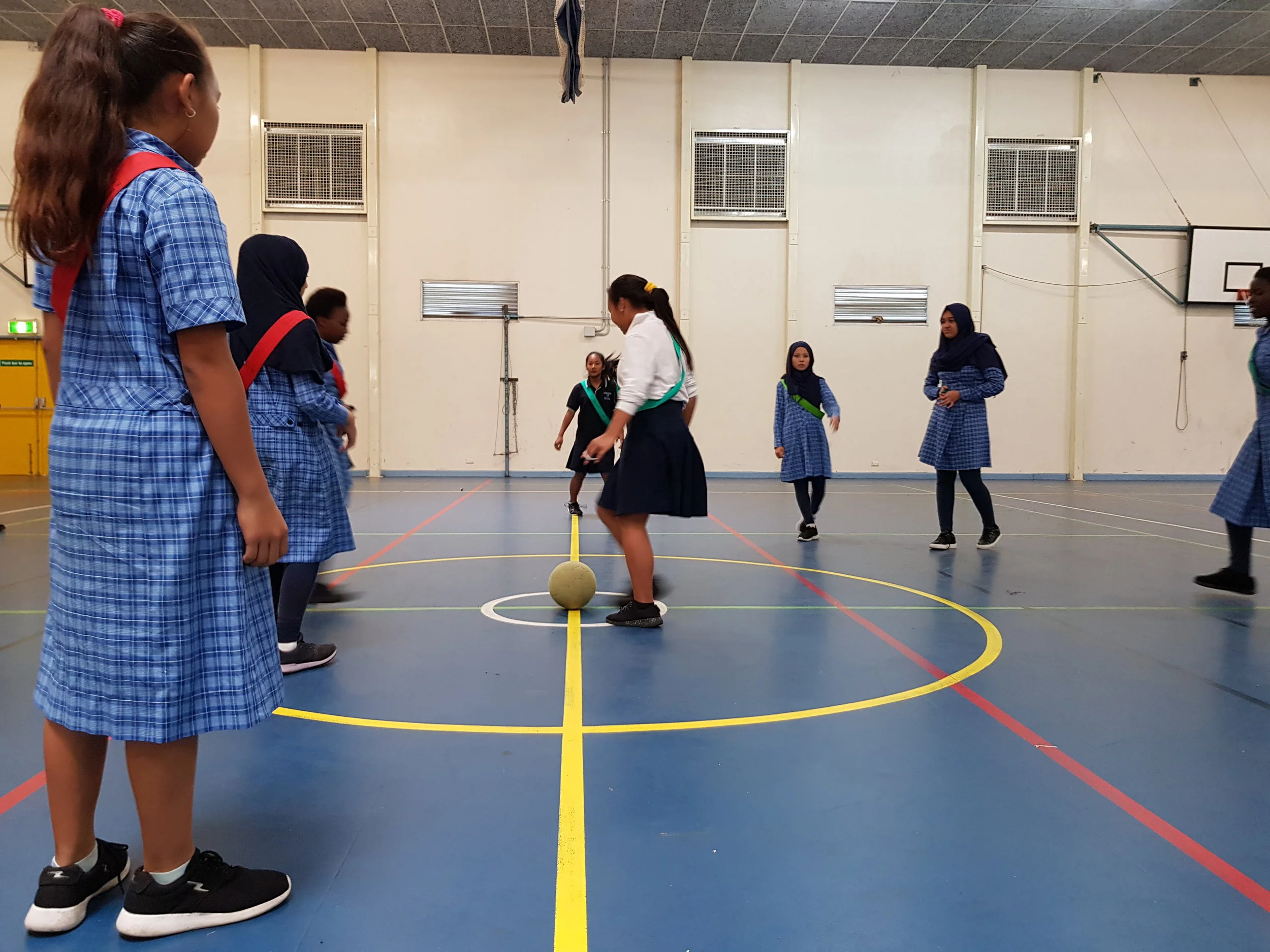 students playing soccer in the school gymnasium