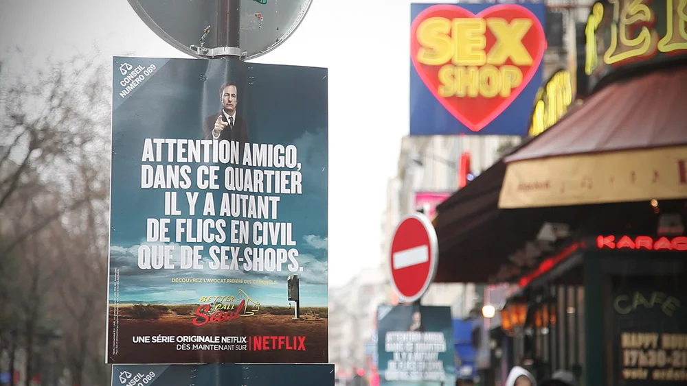 “Here. Never mind the no-clothes girls. This place is crawling with plain-clothes cops.” Place Pigalle (raunchy district), Paris