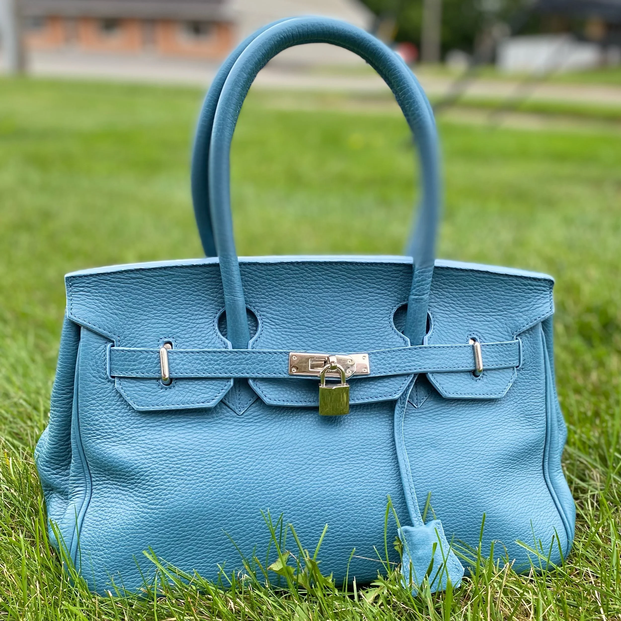 Can you guess which high end bag this was inspired by? 🤗 This genuine leather bag features this lock and unique design to keep all your essentials from falling out your bag! Only $64.99! 🩵