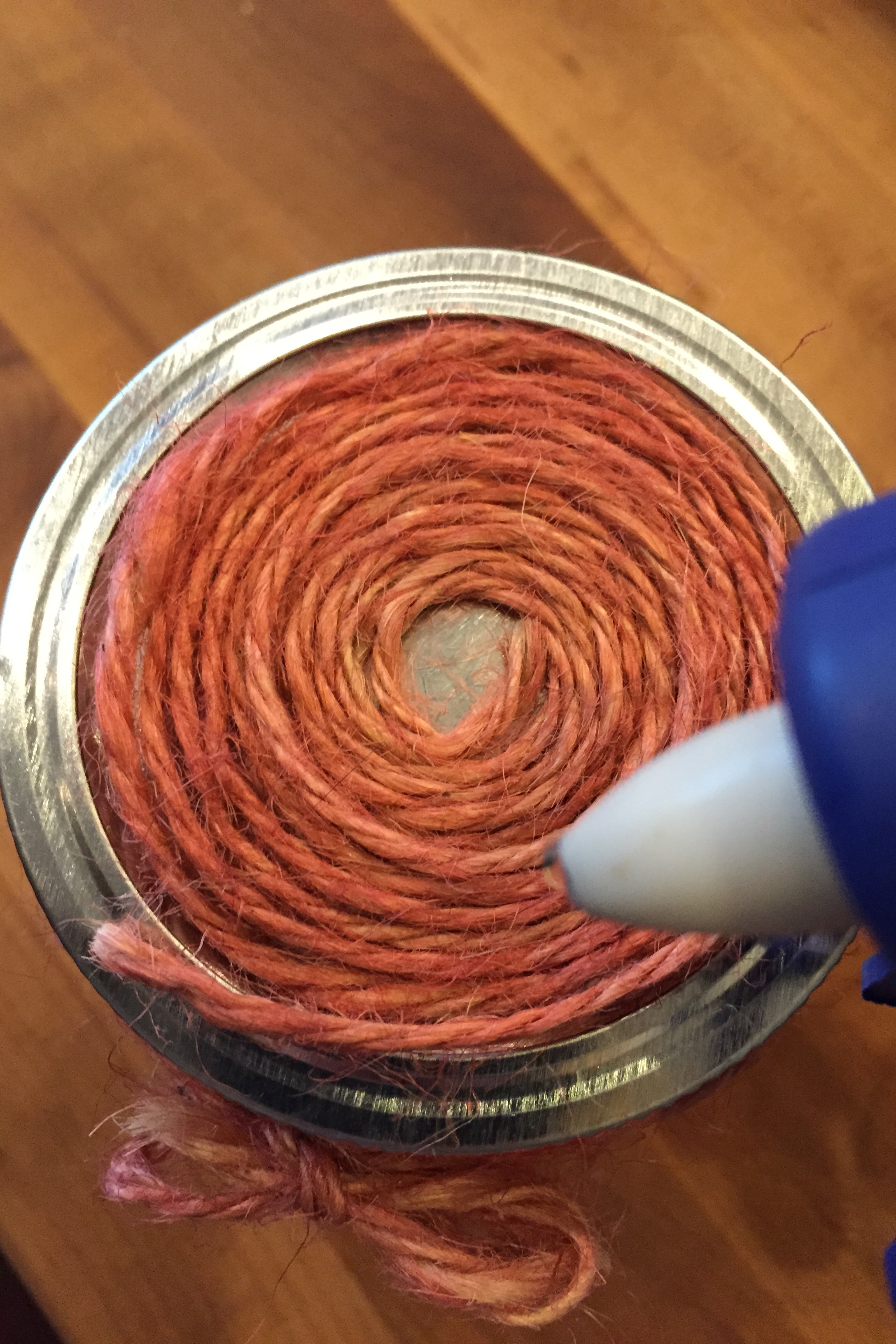 2. Use a touch of glue from a hot glue gun to secure the loose end over top of the spiral. Carefully remove spiral off of top and place aside until step 4.