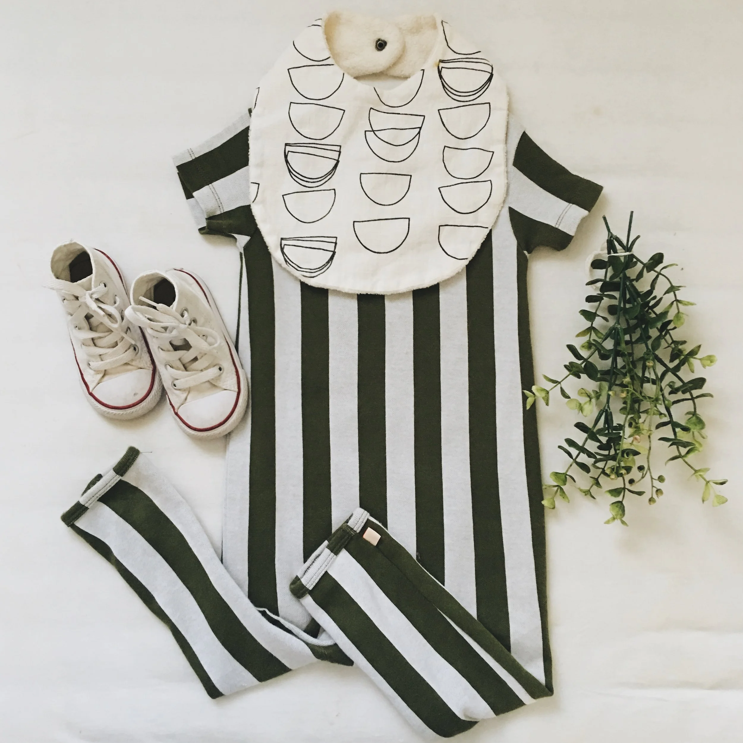 Romper - Tiny Cottons c/o Murray & Finn ; Bib - Wild Winnie ; Sneakers - Converse
