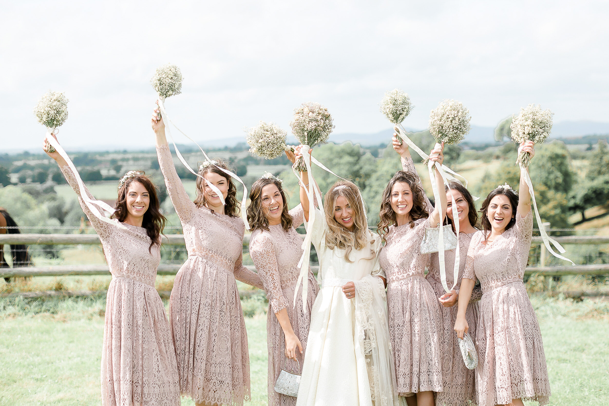 bride.bridesmaids-natural-group-shot-waving-bouquets.jpg